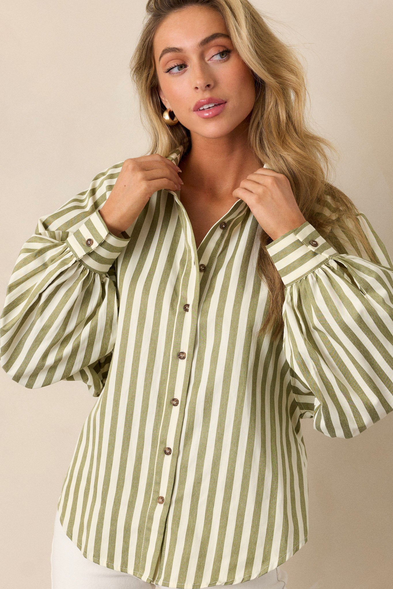 Front angled view of an olive green stripe top featuring a collared neckline, functional button front, vertical green and white stripe design, and cuffed dolman long sleeves