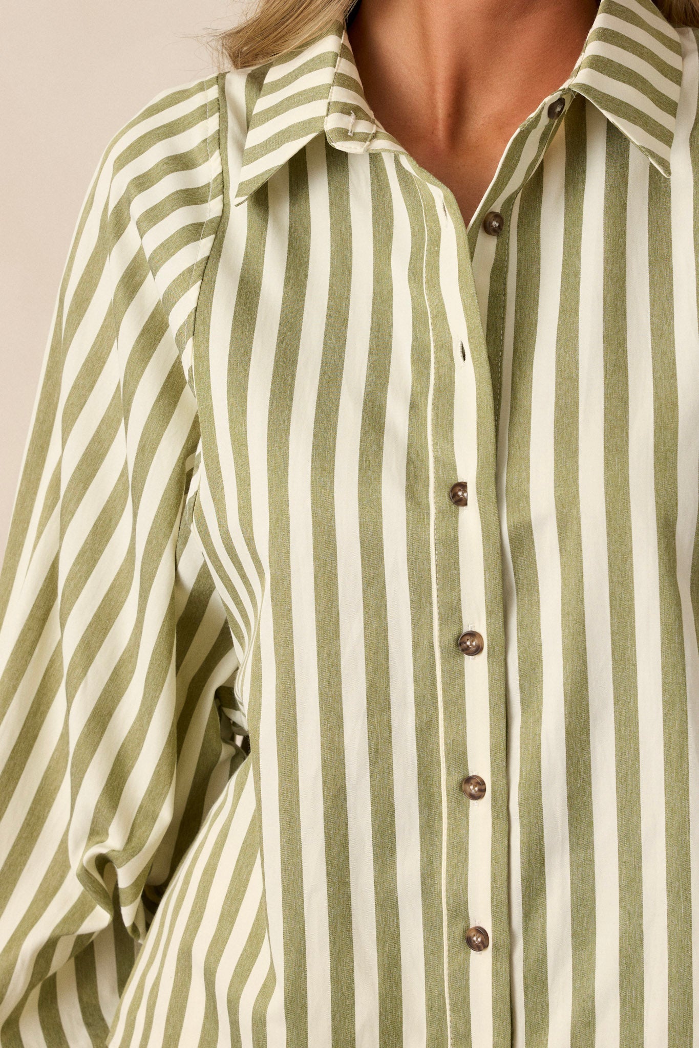 Close-up of the olive green stripe top focusing on the collared neckline, functional button front, vertical stripe design, and the texture of the fabric.