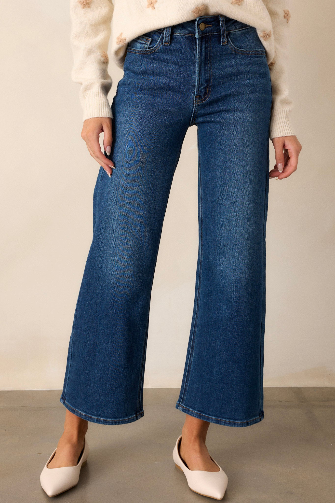 Front view of dark wash jeans featuring a high waisted design, classic button & zipper closure, belt loops, functional front & back pockets, and a cropped length.