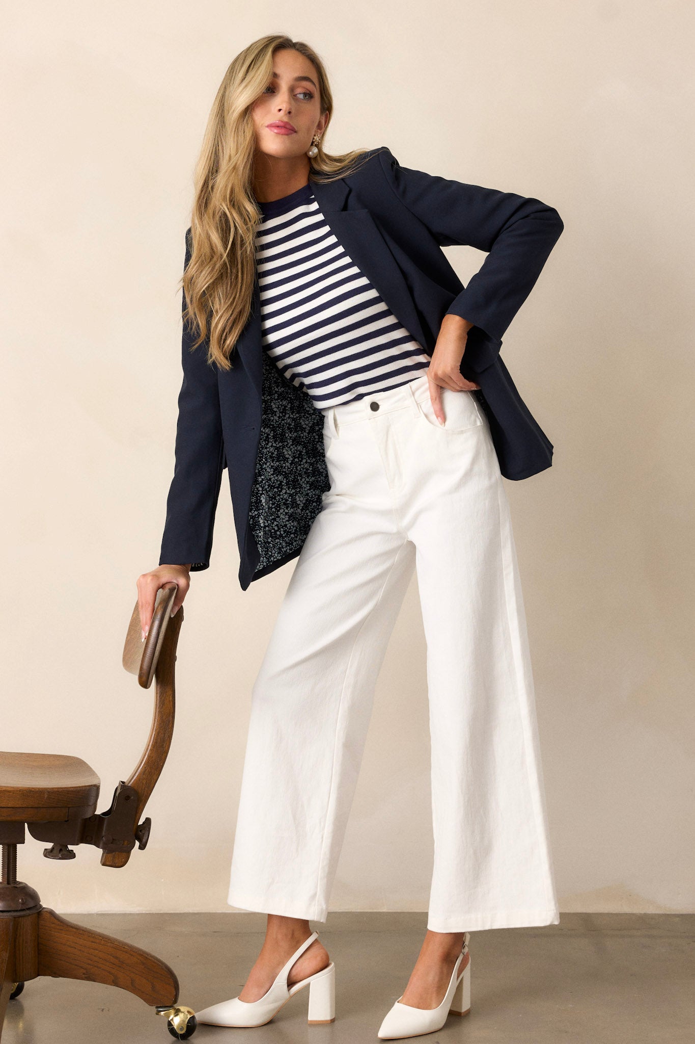 Front view of ivory jeans featuring a high waisted design, button & zipper closure, belt loops, functional front & back pockets, and a wide leg design