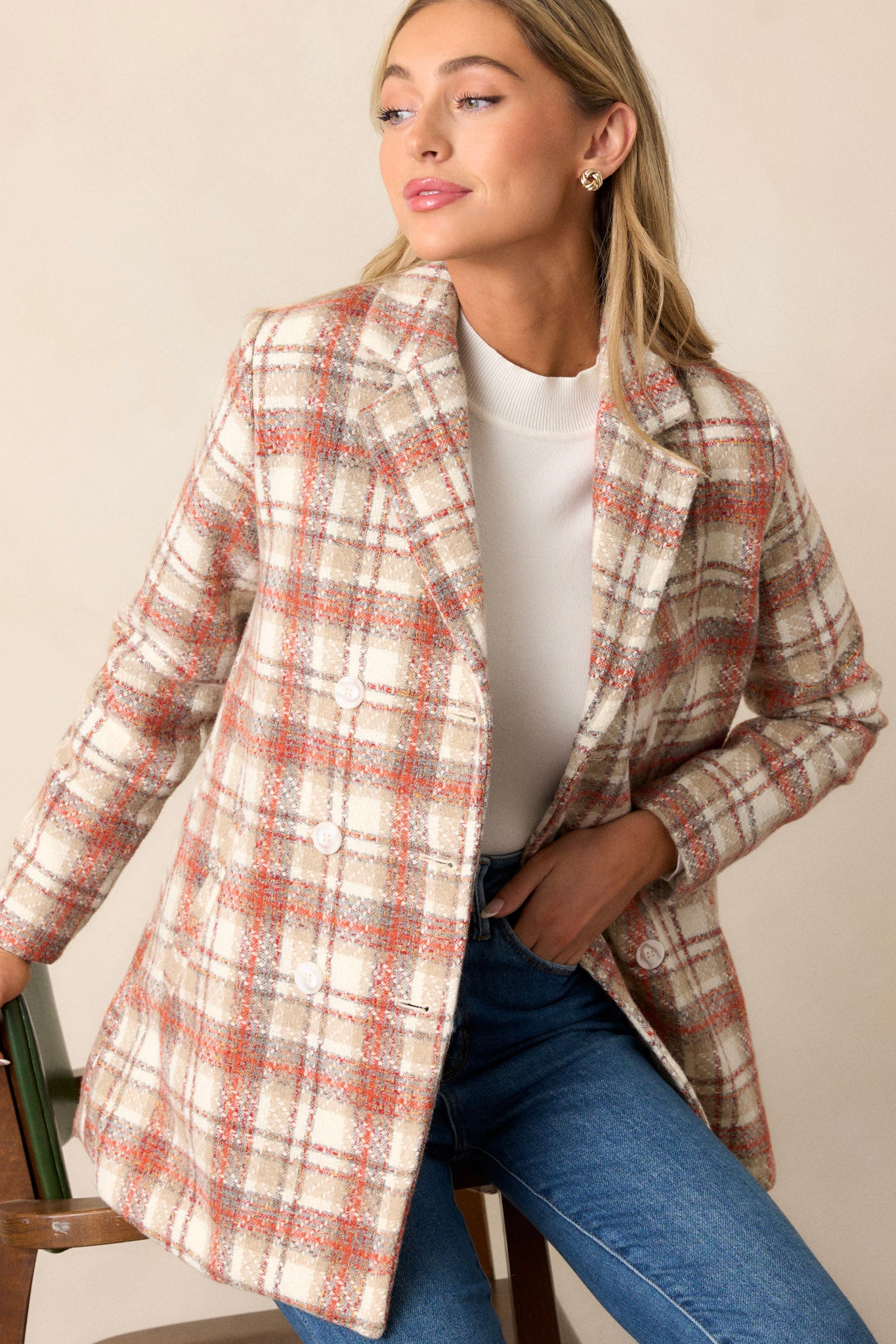 Front view of this coat that features a collared neckline, double breasted buttons on the front, pockets at the waist, and is fitted when buttoned.