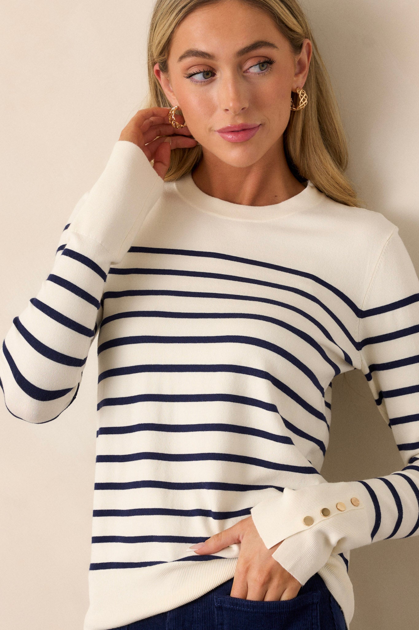 A full-length view of the navy stripe top featuring a high neckline and long sleeves, showcasing the overall fitted silhouette.