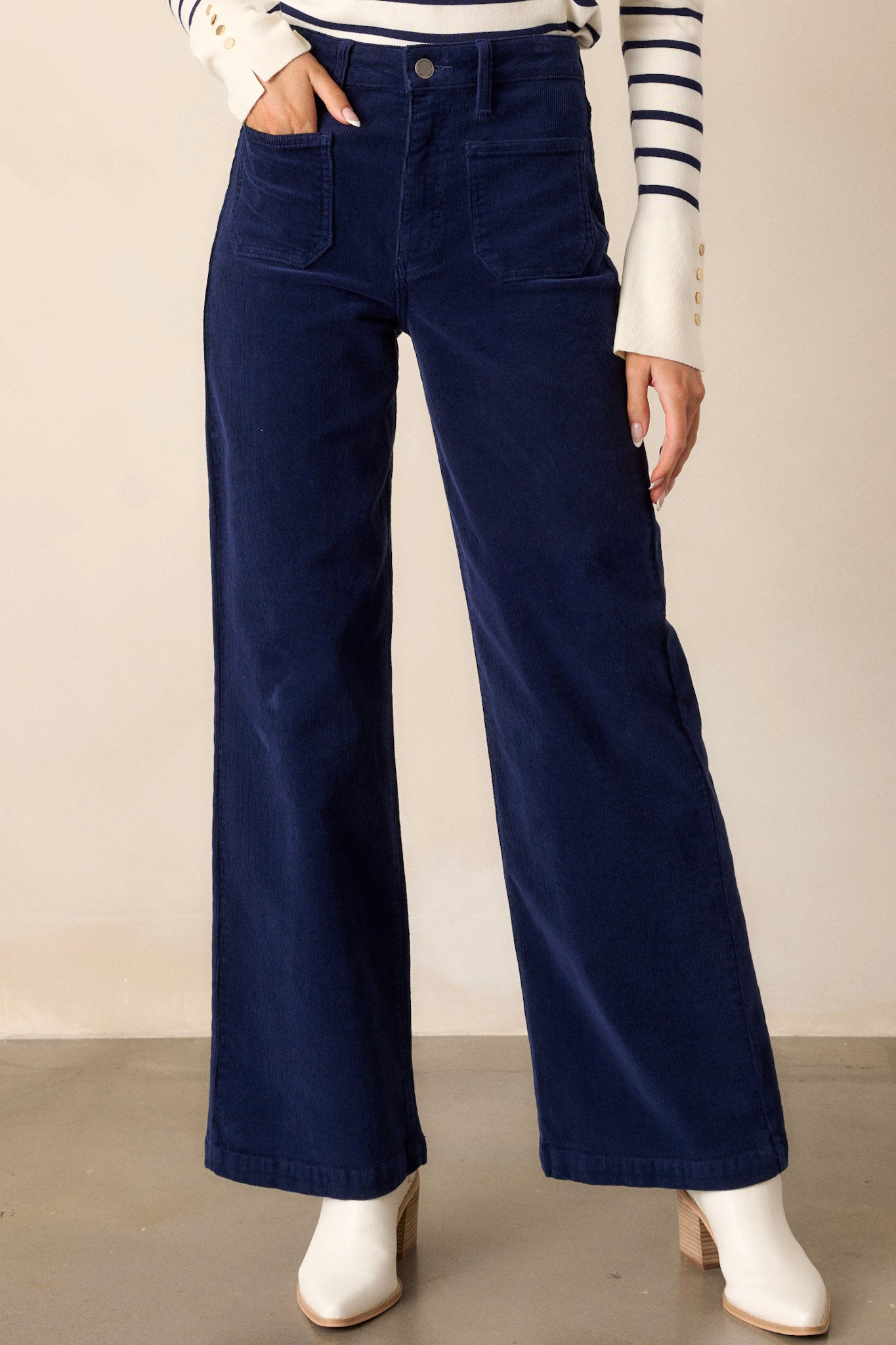 Front view of the navy corduroy jeans showcasing the high-waisted design, straight leg cut, and button-zipper closure, complemented by functional front and back pockets.