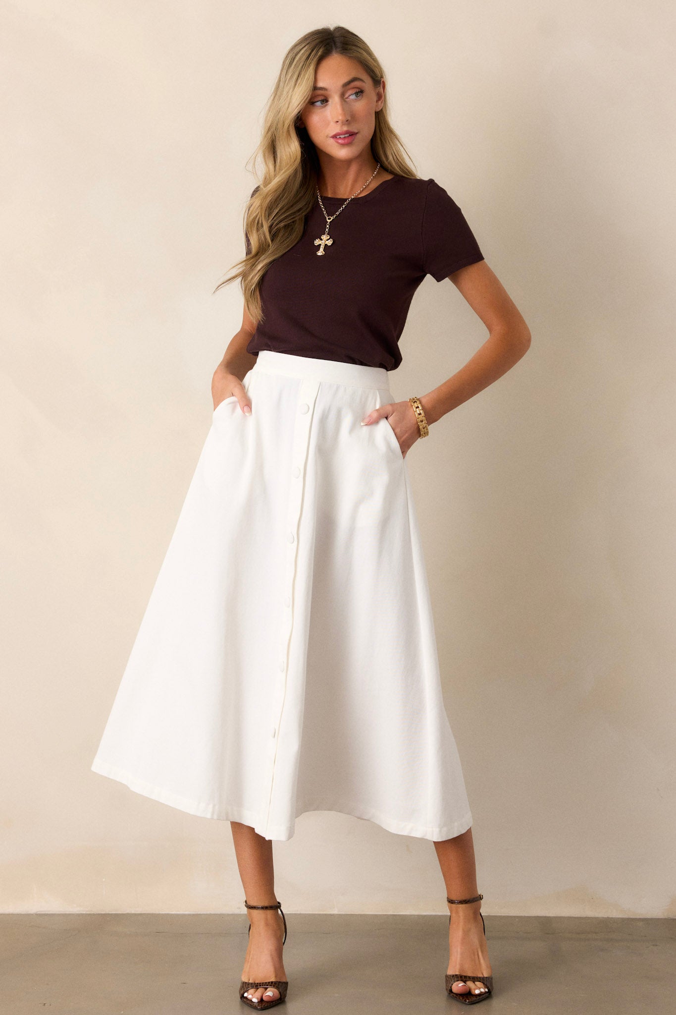 Full body view of this ivory midi shirt that features a high waisted design, a elastic insert along the back of the waistband, and faux buttons down the front.