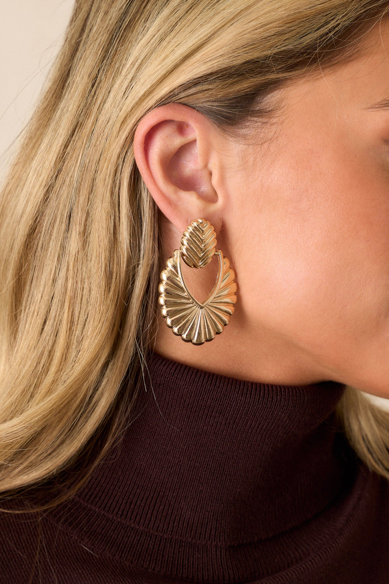 A detailed close-up of the earrings, focusing on the secure post backing and the connection between the leaf-shaped stud and the fan-shaped drop pendant.