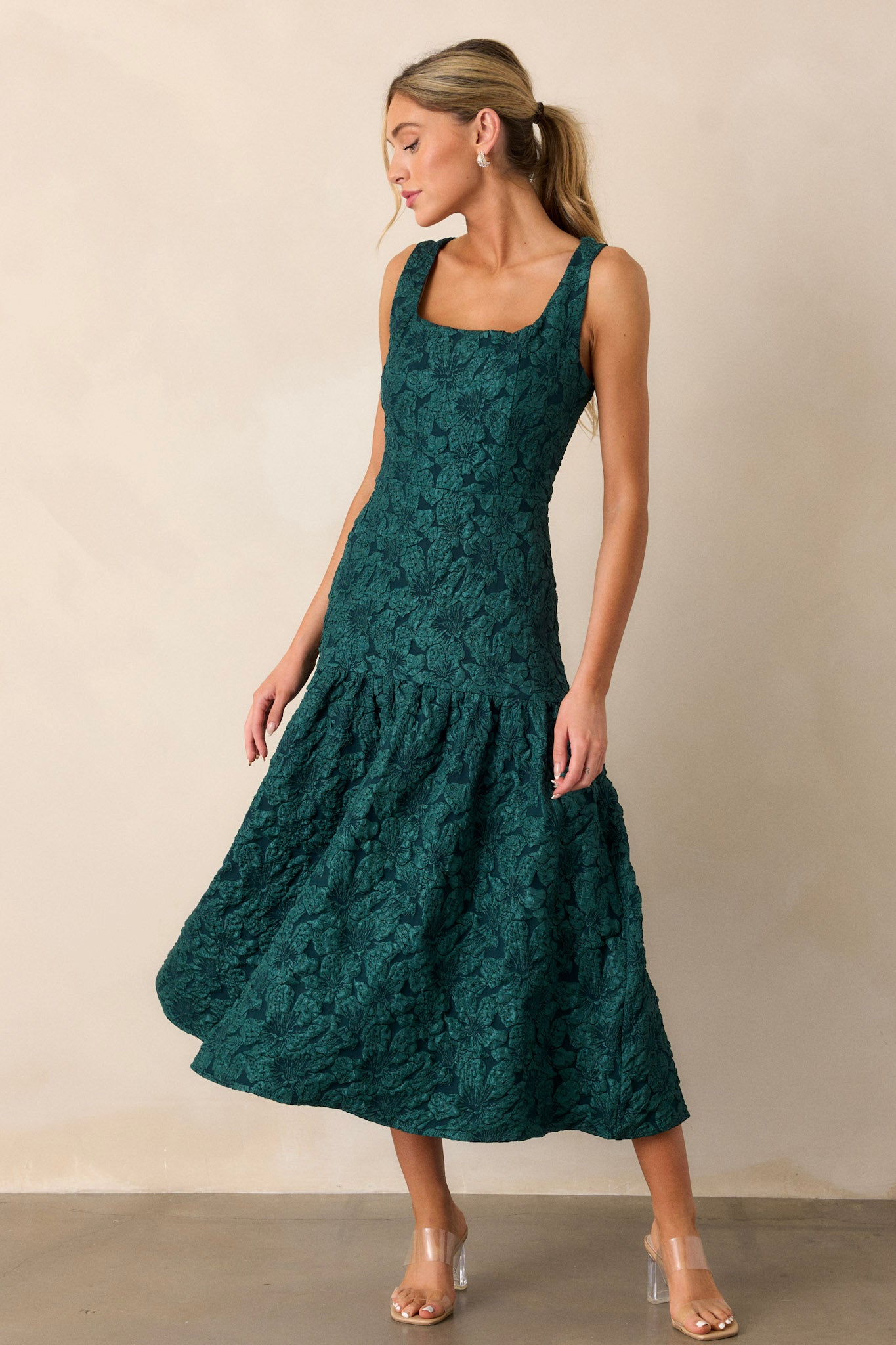 Full view of the green dress highlighting the sleeveless design, square neckline, and subtle jacquard pattern on the bodice.