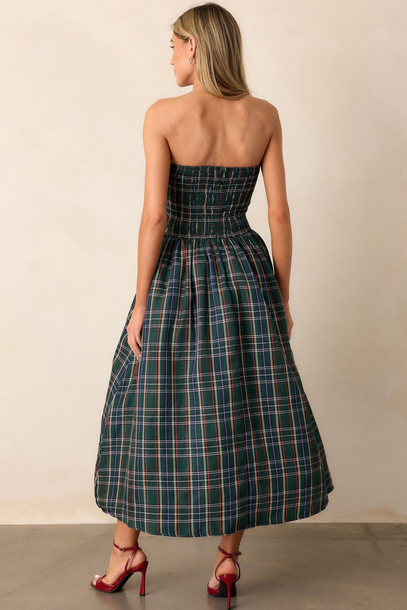 A back view of the dress, highlighting the smocked back and the discrete back zipper that enhances the dress's sleek and polished appearance.