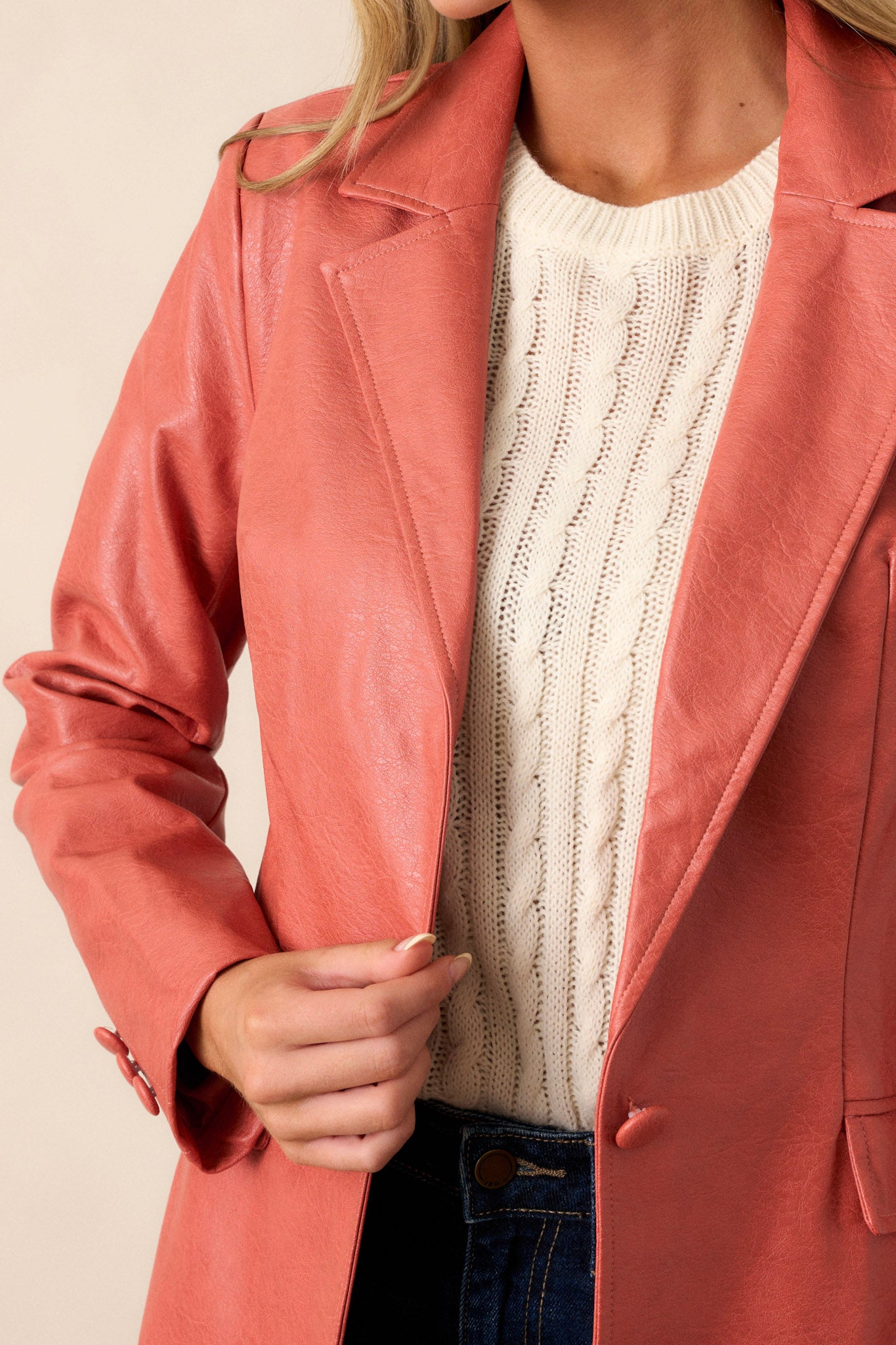 A close-up of the faux leather texture, emphasizing the luxurious feel and the vibrant red orange color that makes the jacket stand out.