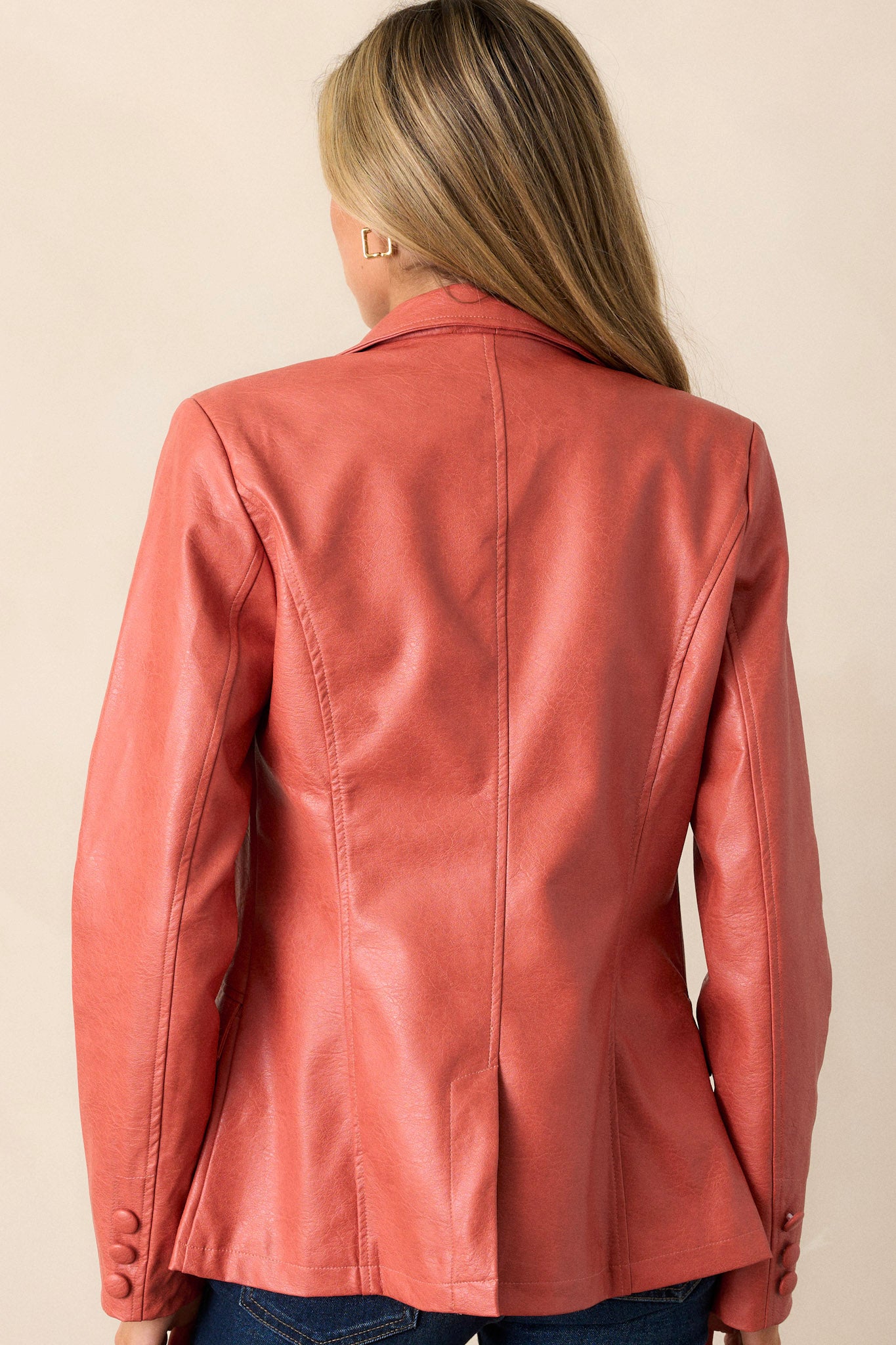 A back view of the jacket, highlighting the clean lines and overall structure, while also showcasing the long sleeves and how they taper down to the non-functional cuffs.