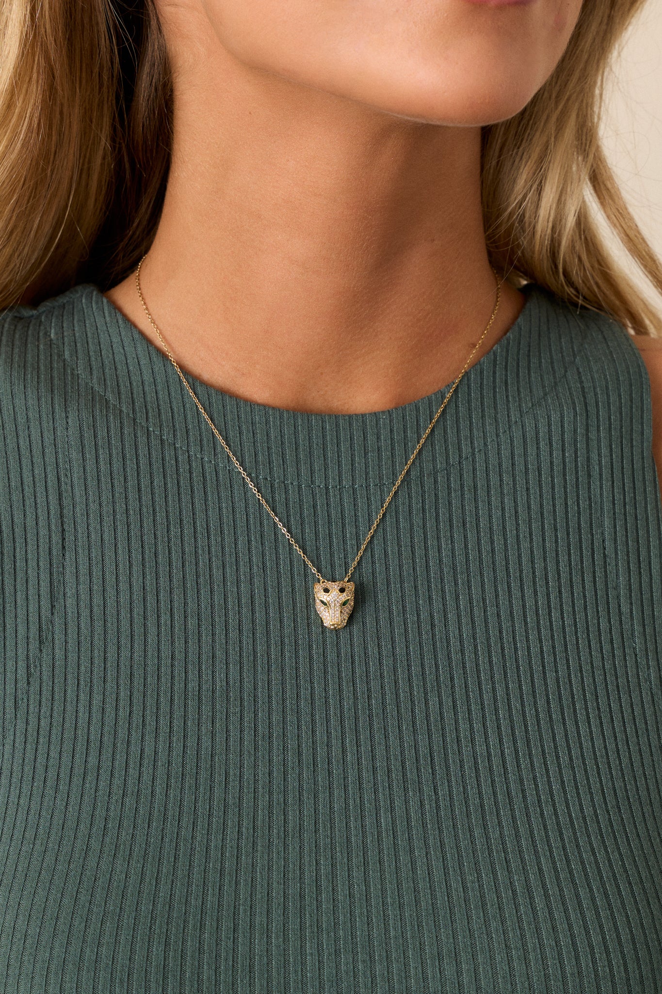 This gold necklace features gold hardware, a thin gold chain, a gold pavè rhinestone panther pendant and a lobster claw closure.