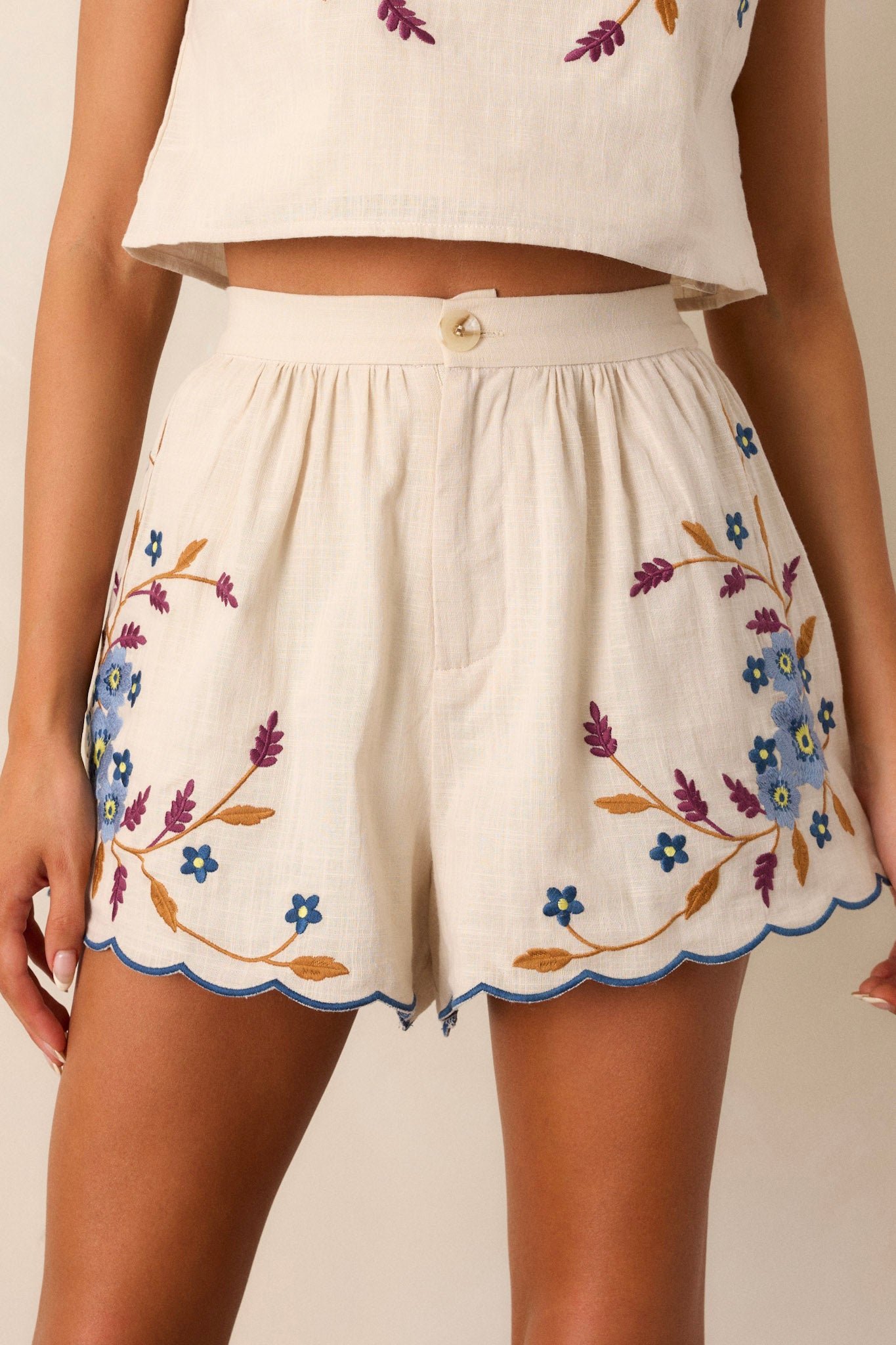 Cropped image focusing on the waistband of the shorts, emphasizing the high-rise fit and the zipper and button closure.