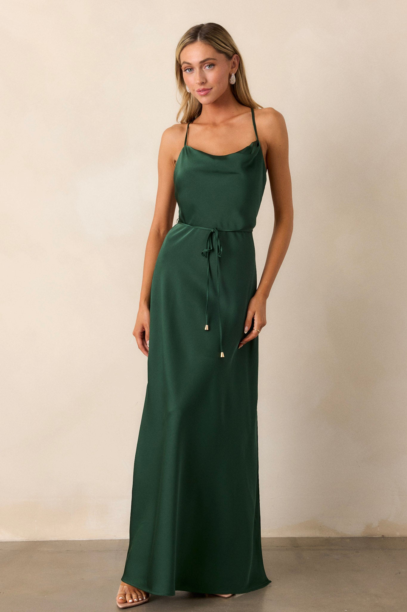 Full-body shot of the emerald dress, drawing attention to the top portion with the cowl neckline and self-tie belt with gold hardware.