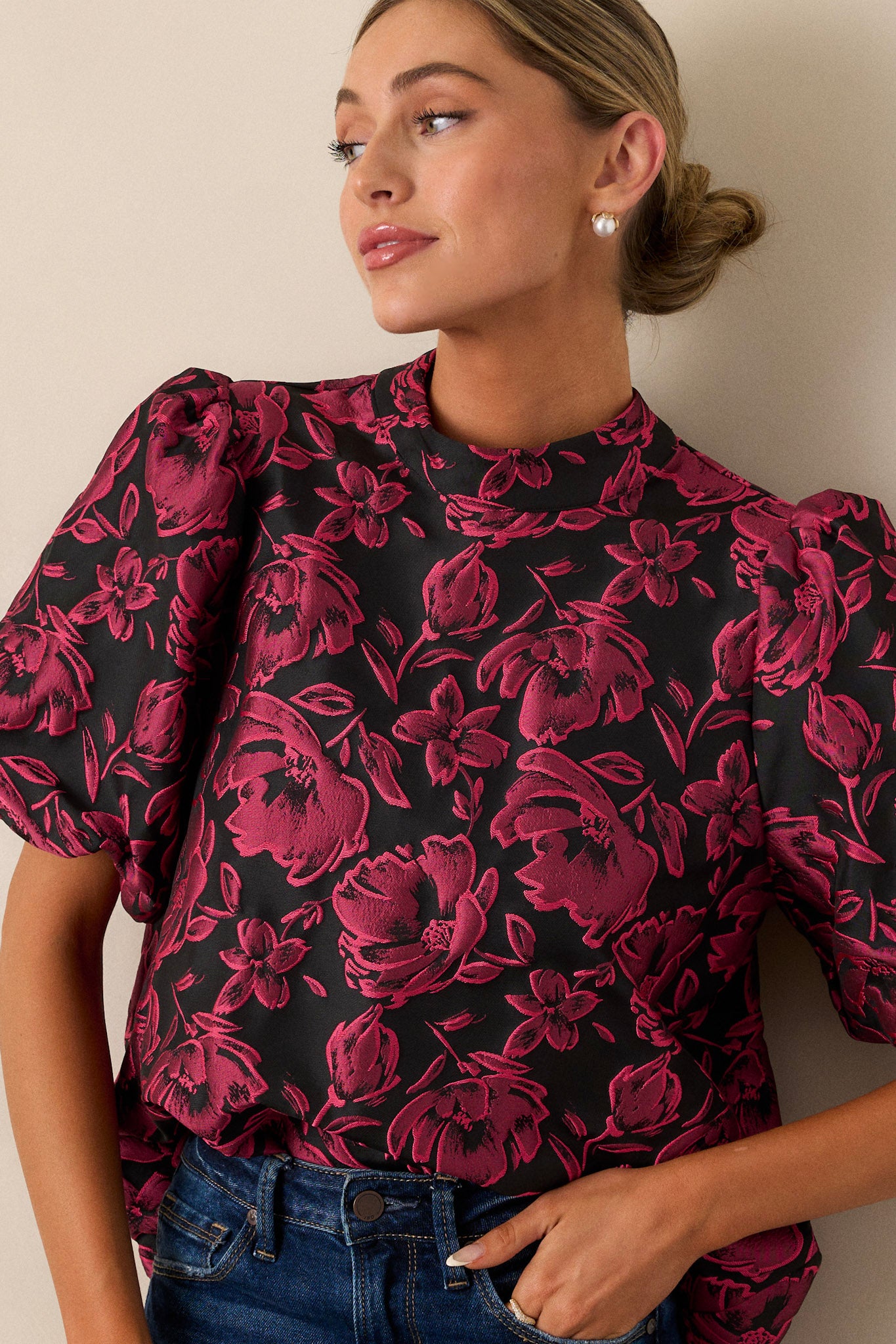 A close-up view of the upper section of the top, focusing on the mock neckline and the faux velvet self-tie bow, emphasizing the neckline's structure.