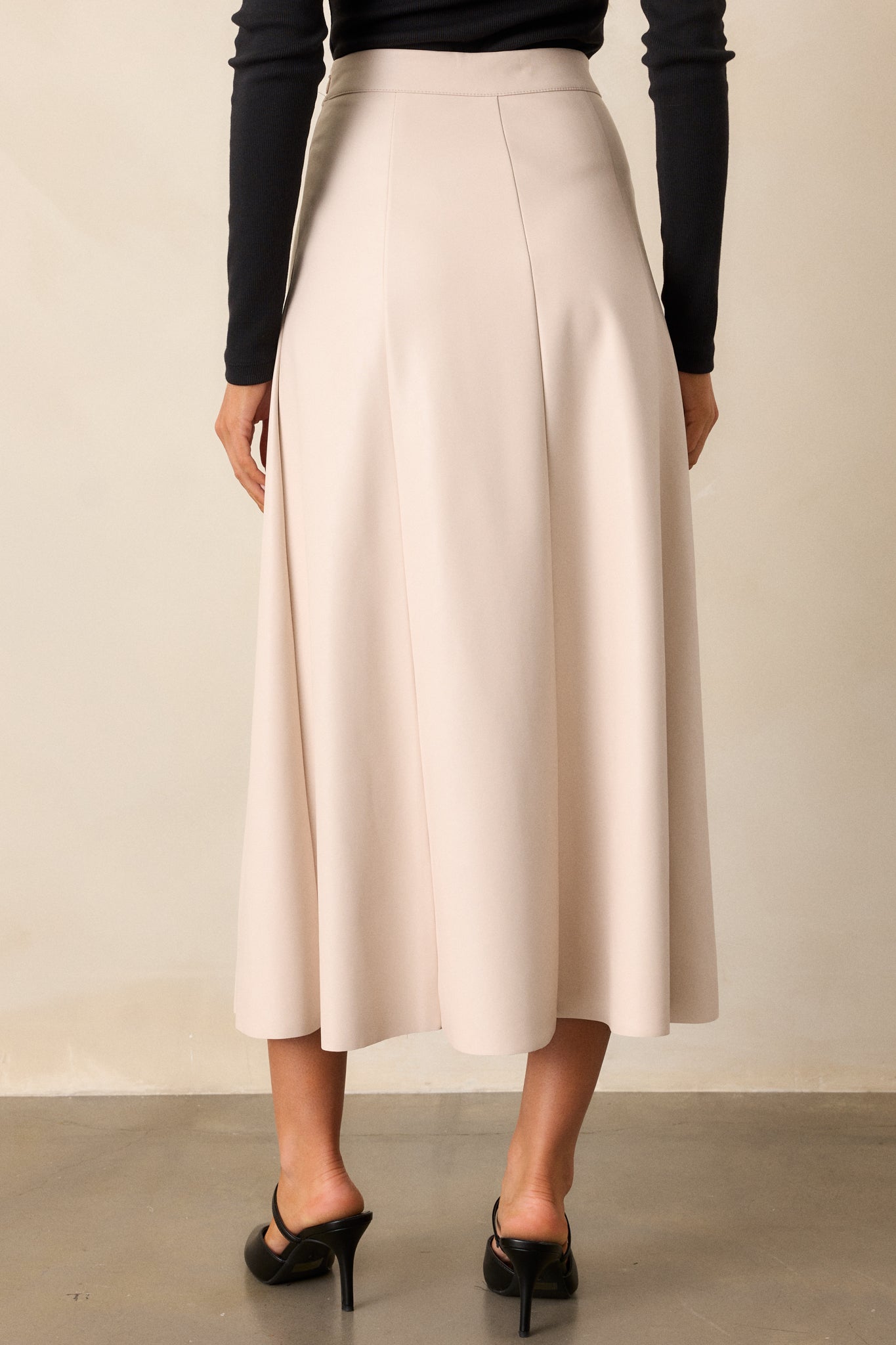 Rear view of the beige skirt, highlighting the A-line shape and the discrete zipper detail, with emphasis on the clean lines and overall fit.