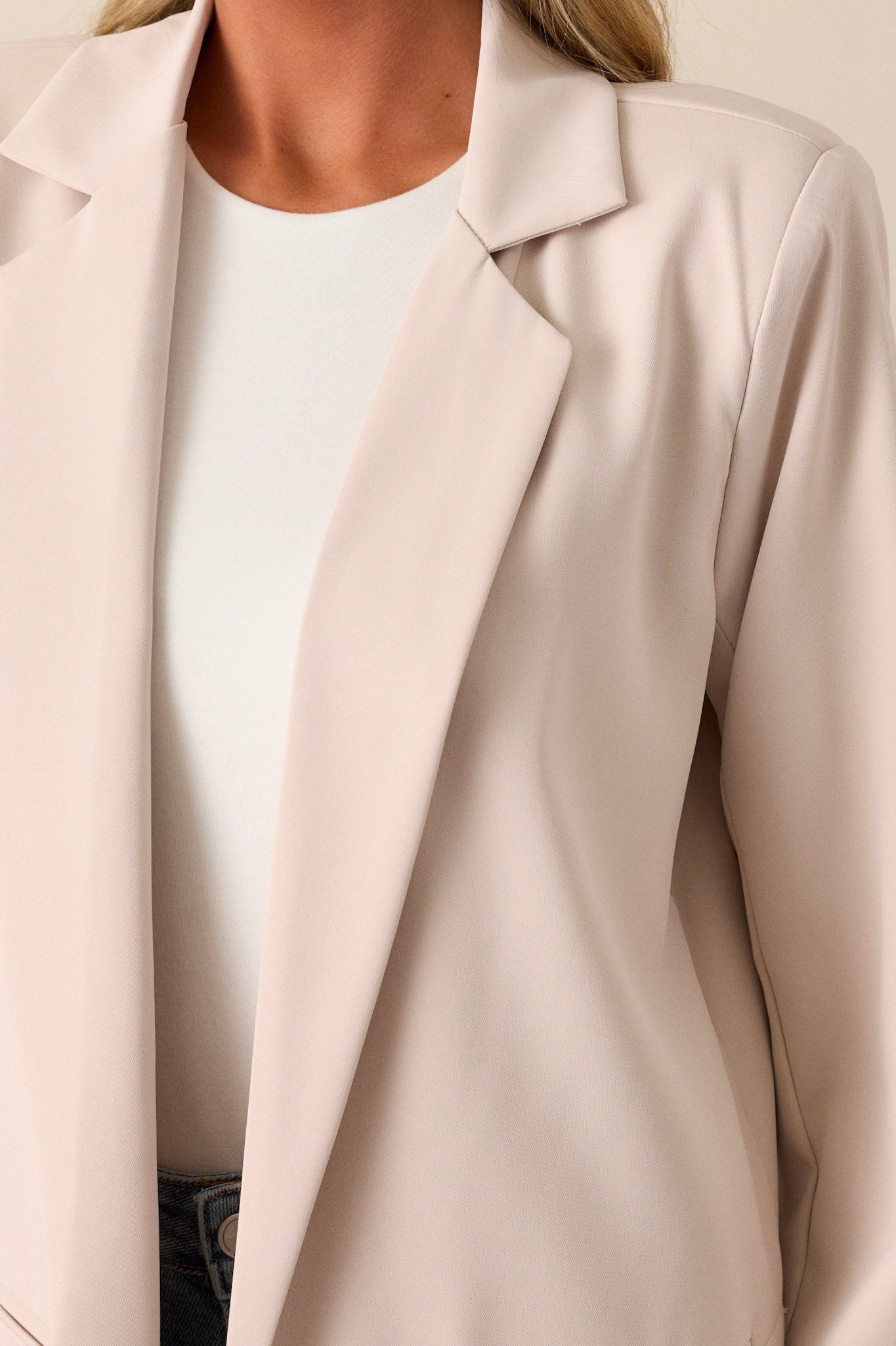 Close-up detail of the functional front pockets and the precise stitching along the tapered seams of the blazer.