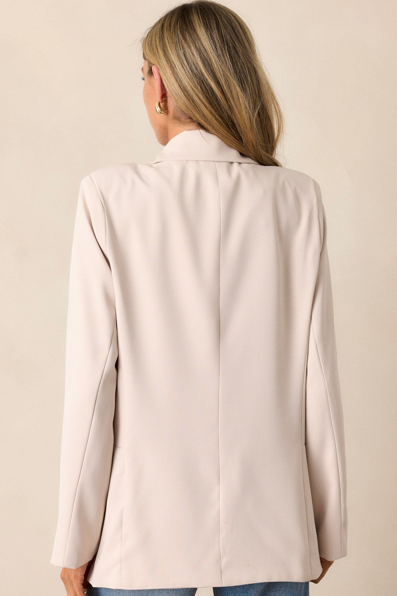 Rear view of the ecru blazer, highlighting the tapered design and the clean lines along the back.