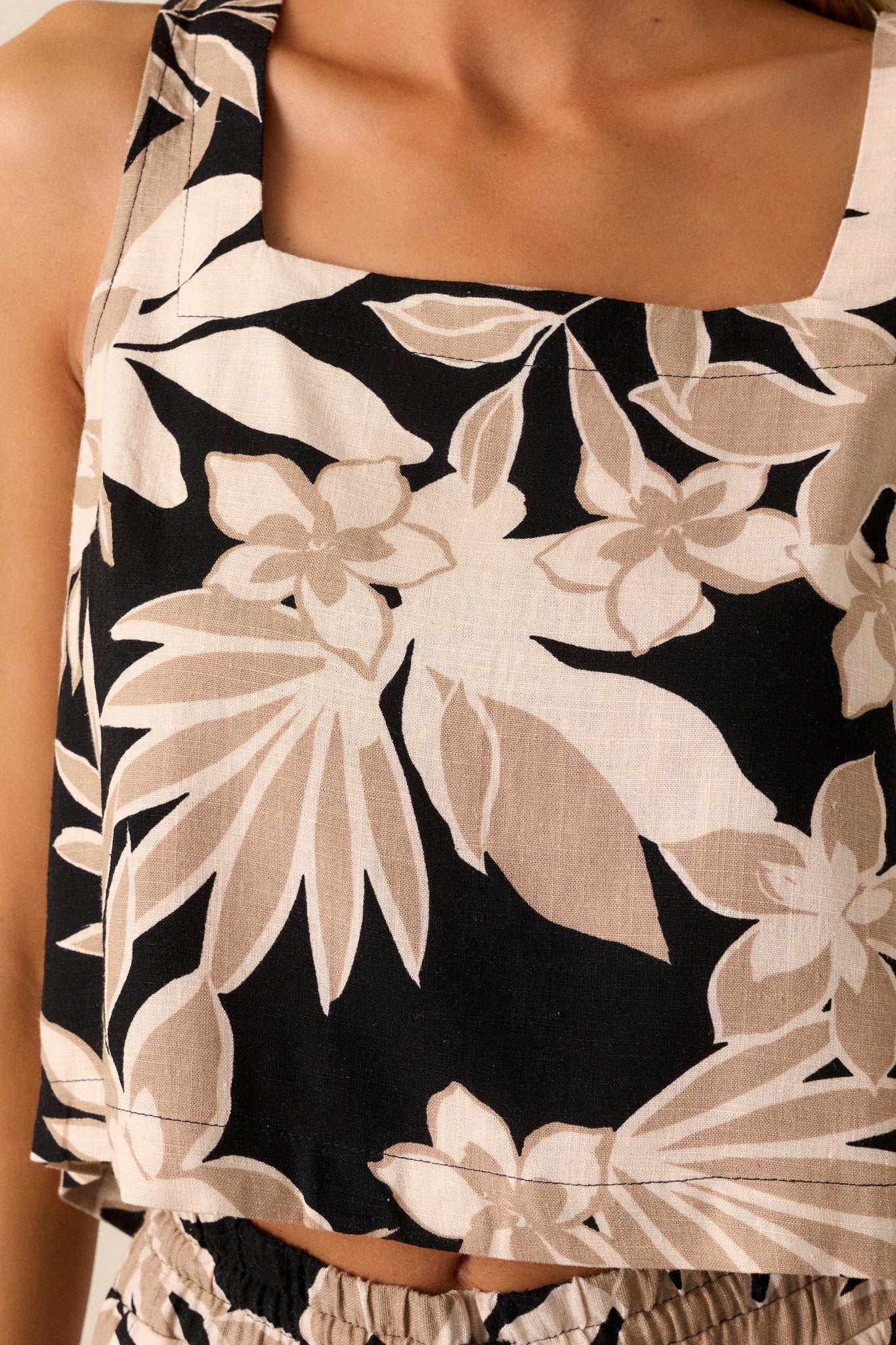 Close-up of the floral design, showing the texture and color details on the tan material.