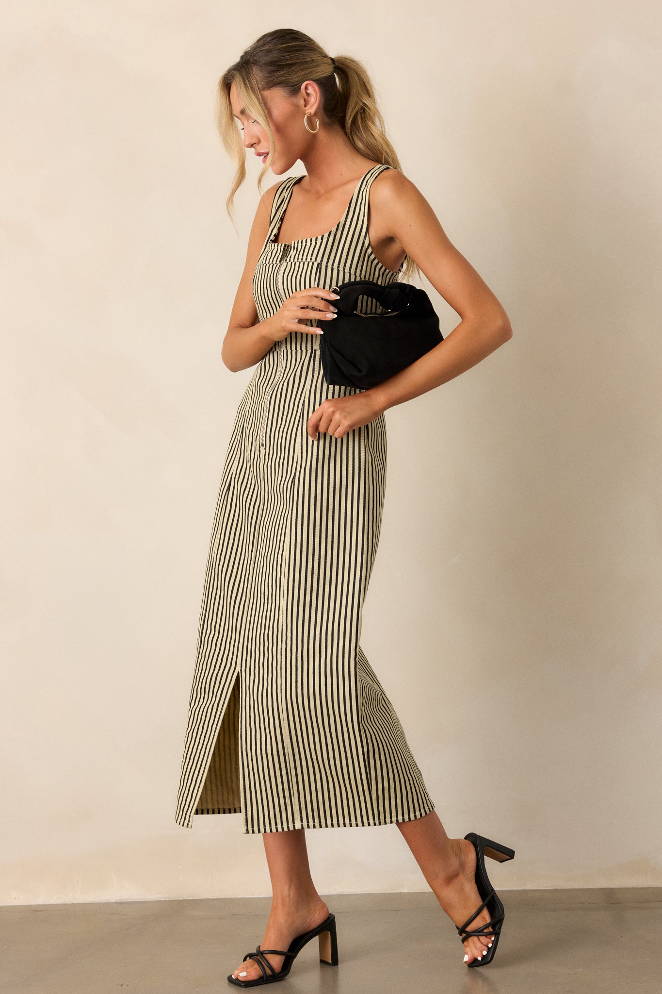 Full-length view showcasing the vertical stripe pattern and the sleek fit of the dress, with attention to the functional zip front and front slit.