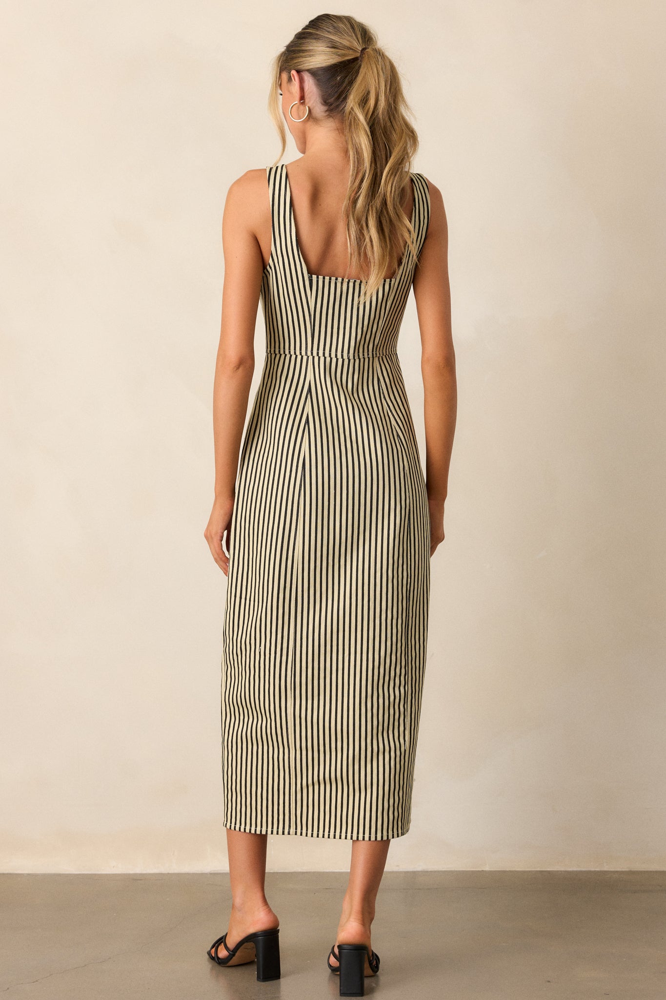 Rear view of the black stripe dress, showcasing the thick straps and the continuation of the vertical stripe pattern across the back.