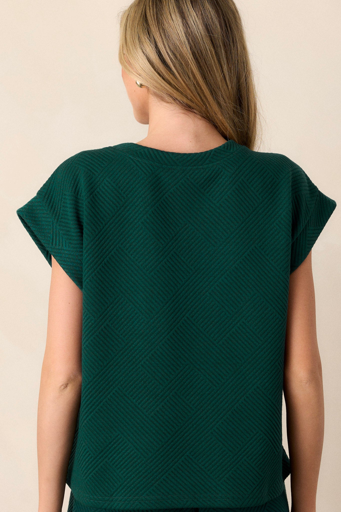 Back view of the top highlighting the continuation of the subtle crisscross texturing and the relaxed fit of the garment.