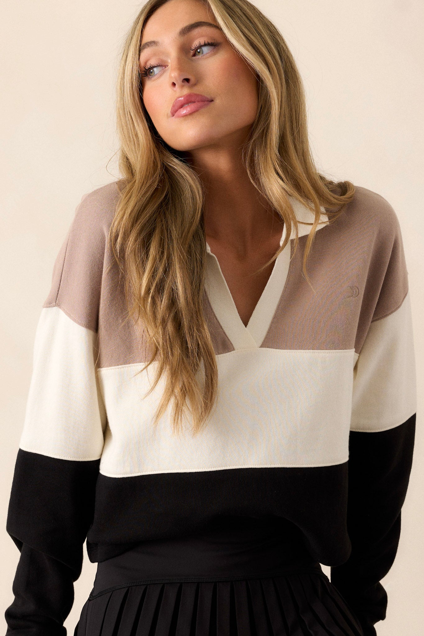 This collared top features a collared v-neck, ribbed arm cuffs and soft fabric material.