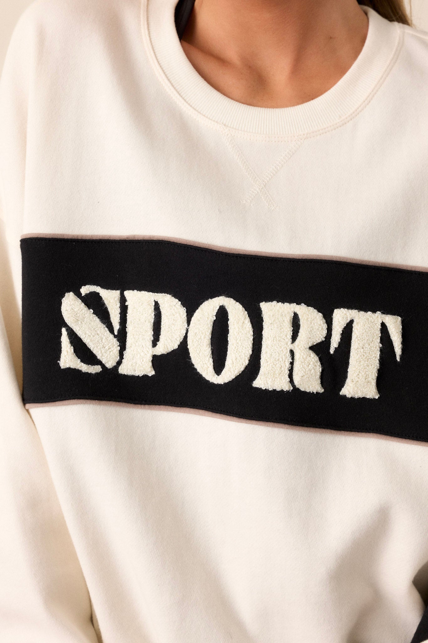 A close-up image focusing on the embroidered wording in the terry cloth, highlighting the texture and the contrast with the ivory fabric.