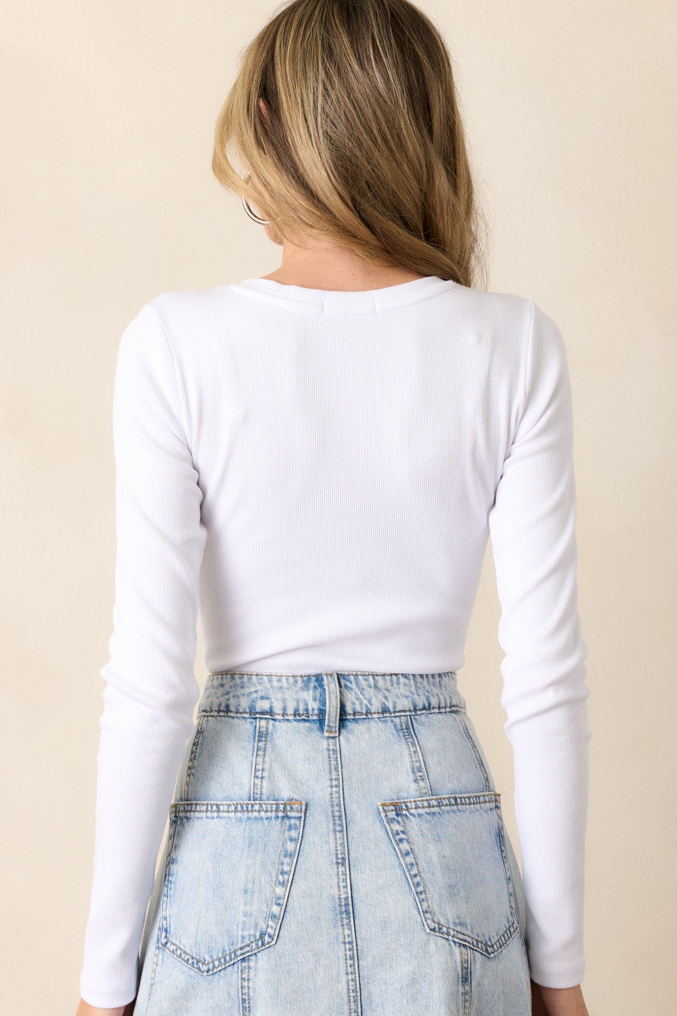 A back view of the white bodysuit featuring the ribbed fabric, showcasing the texture and craftsmanship of the bodysuit.