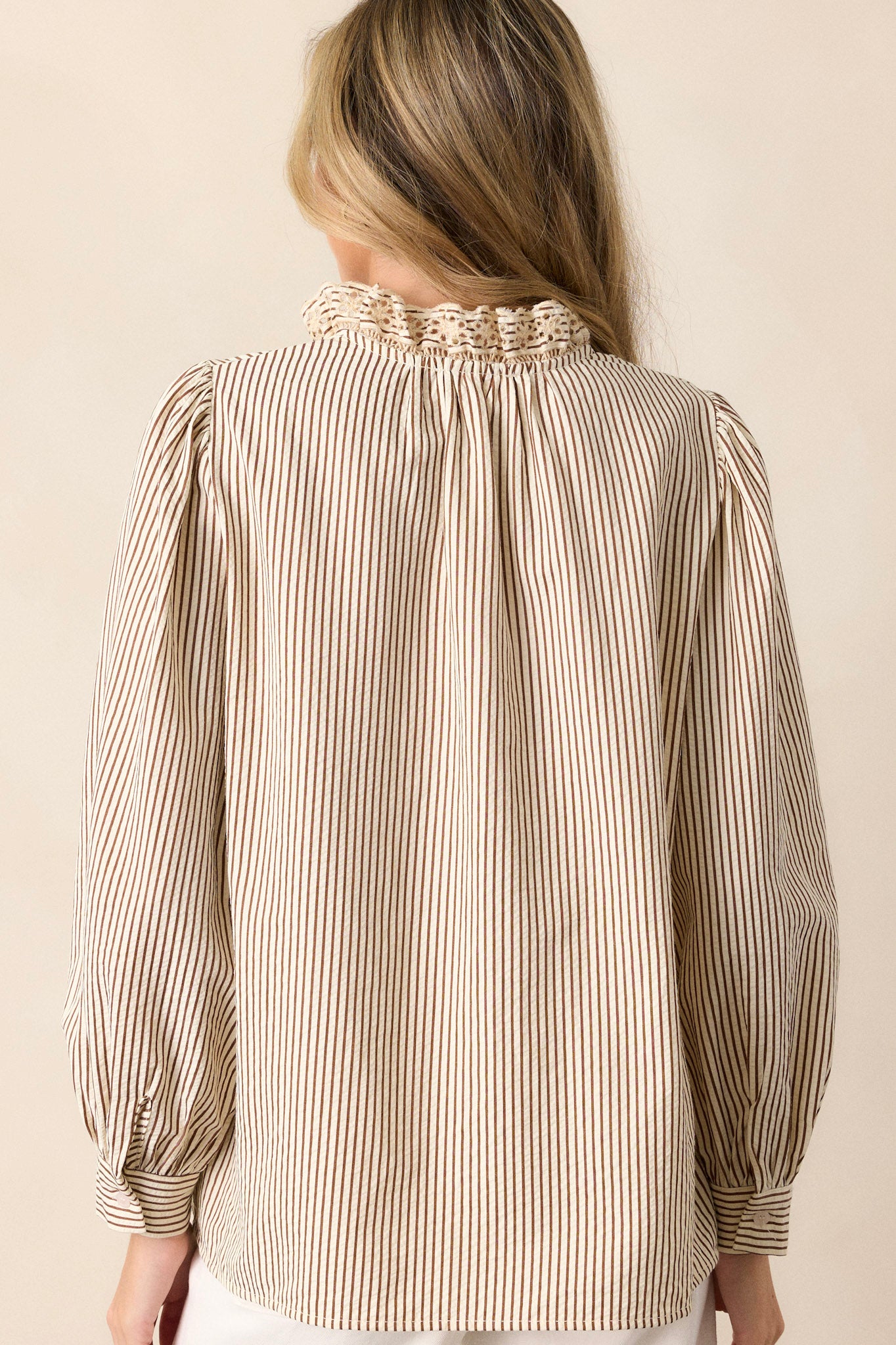 Back view of this brown stripe top that features a lace collar, a functional button front bust, a vertical stripe pattern, brown and ivory stripes and puffed long sleeves.