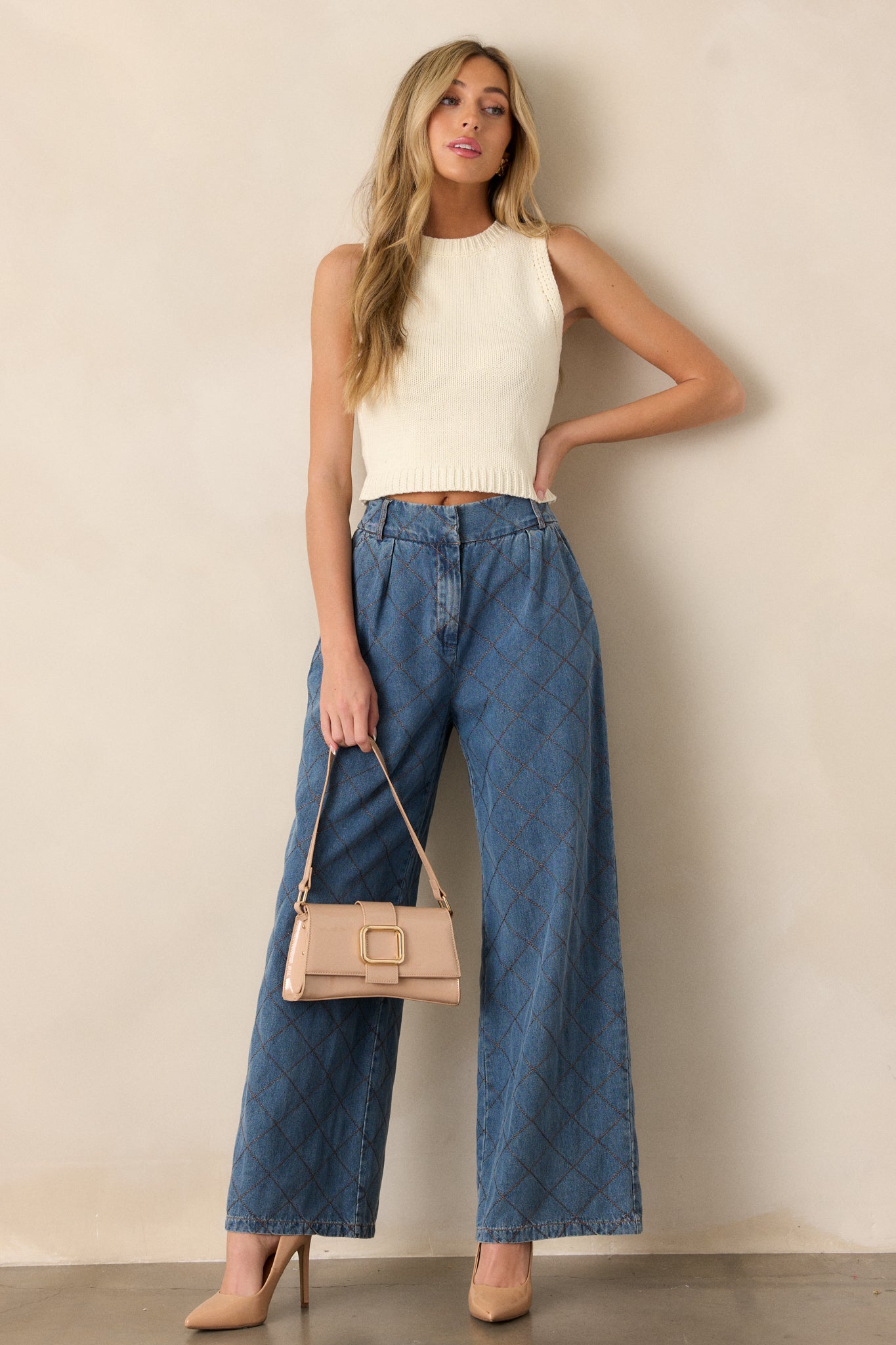 Full body view of quilted jeans featuring a high waisted design, a hook and bar closure, functional belt loops, hip pockets, a quilted design and a wide leg.