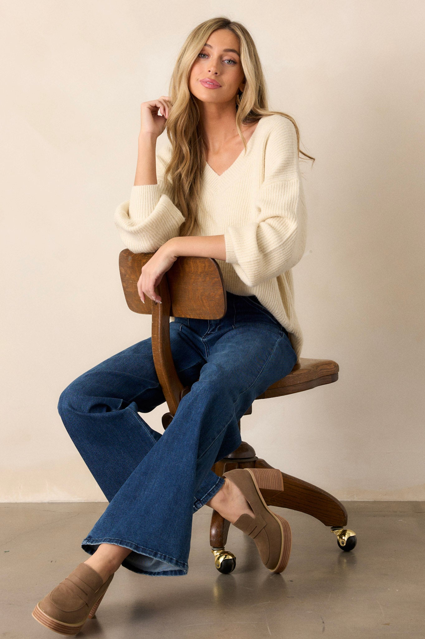 This sweater features a v-neckline, long sleeves with ribbed cuffs, a ribbed hemline, and slits that go up each side with the back being slightly longer.