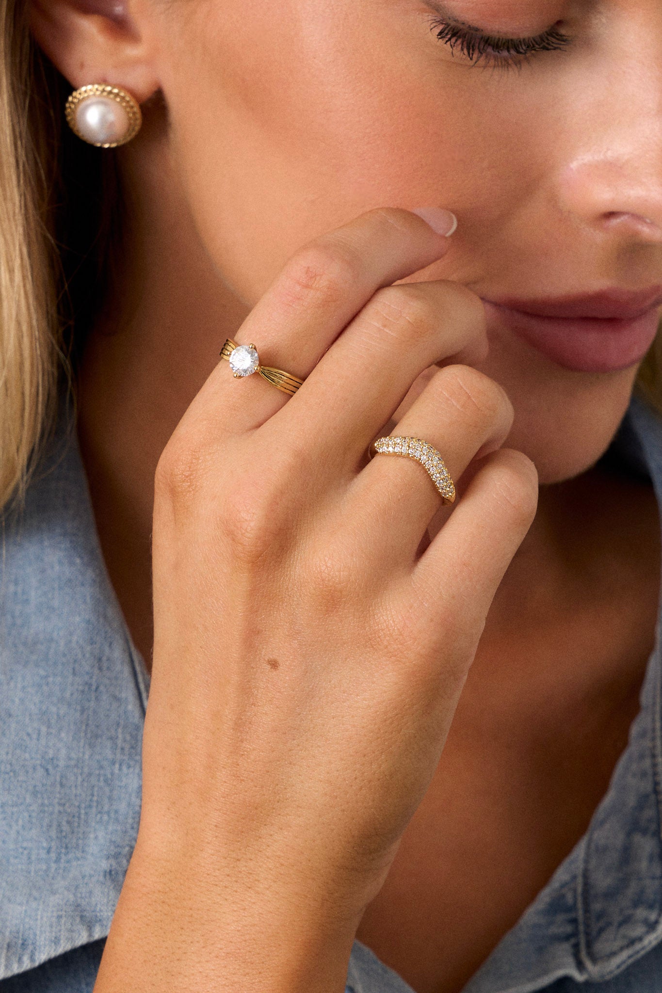 A close-up shot of the first ring, emphasizing the arched middle adorned with tiny rhinestones and the detailed texture of the solid band.