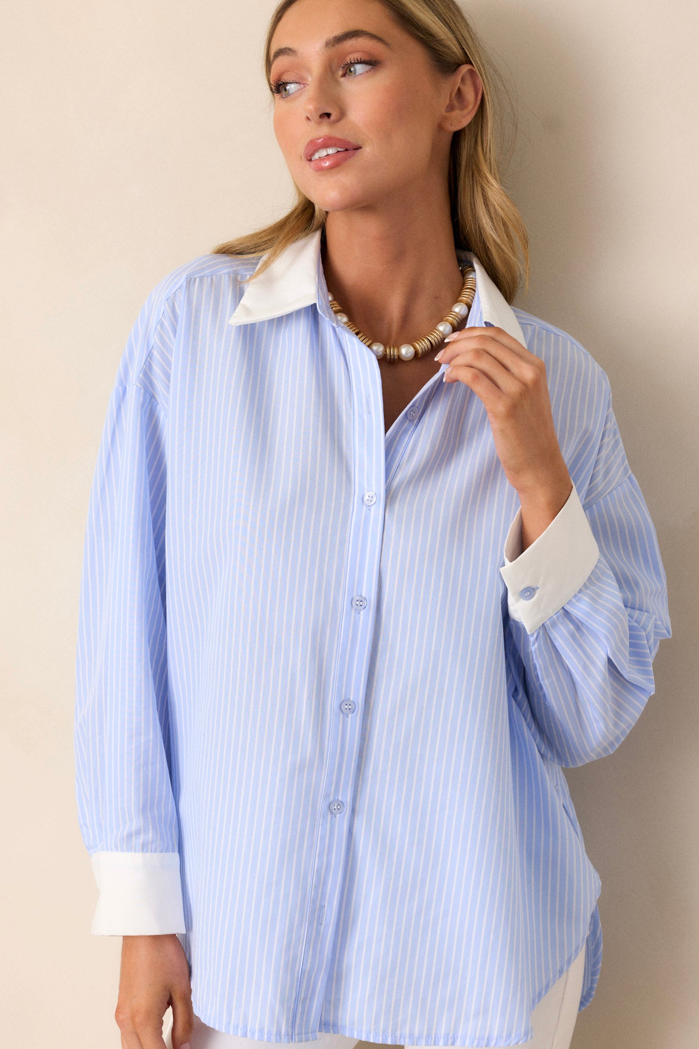 Front view of a stripe button-front shirt featuring a collared neckline, a functional button front, a vertical stripe design, an oversized fit, side slits in the hem, and 3/4 sleeves.