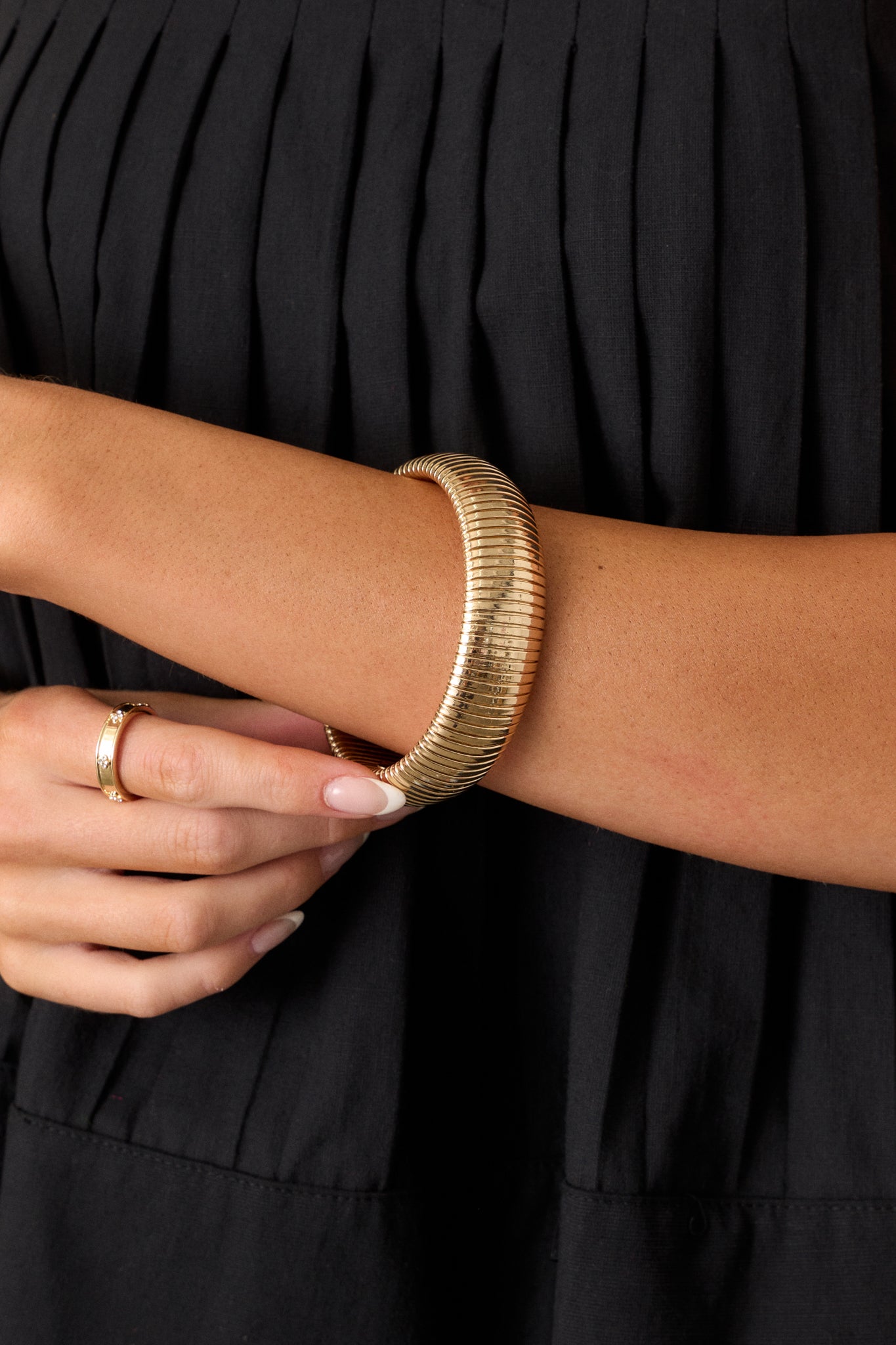 Detailed shot of the gold bracelet showcasing the fine horizontal beading and the closed structure with minimal stretch.