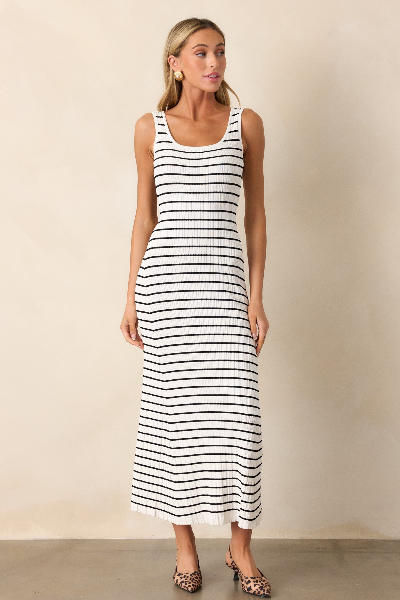 Full length view of a white stripe dress with a scoop neckline, a classic stripe design, a soft ribbed texture, and a bodycon fit