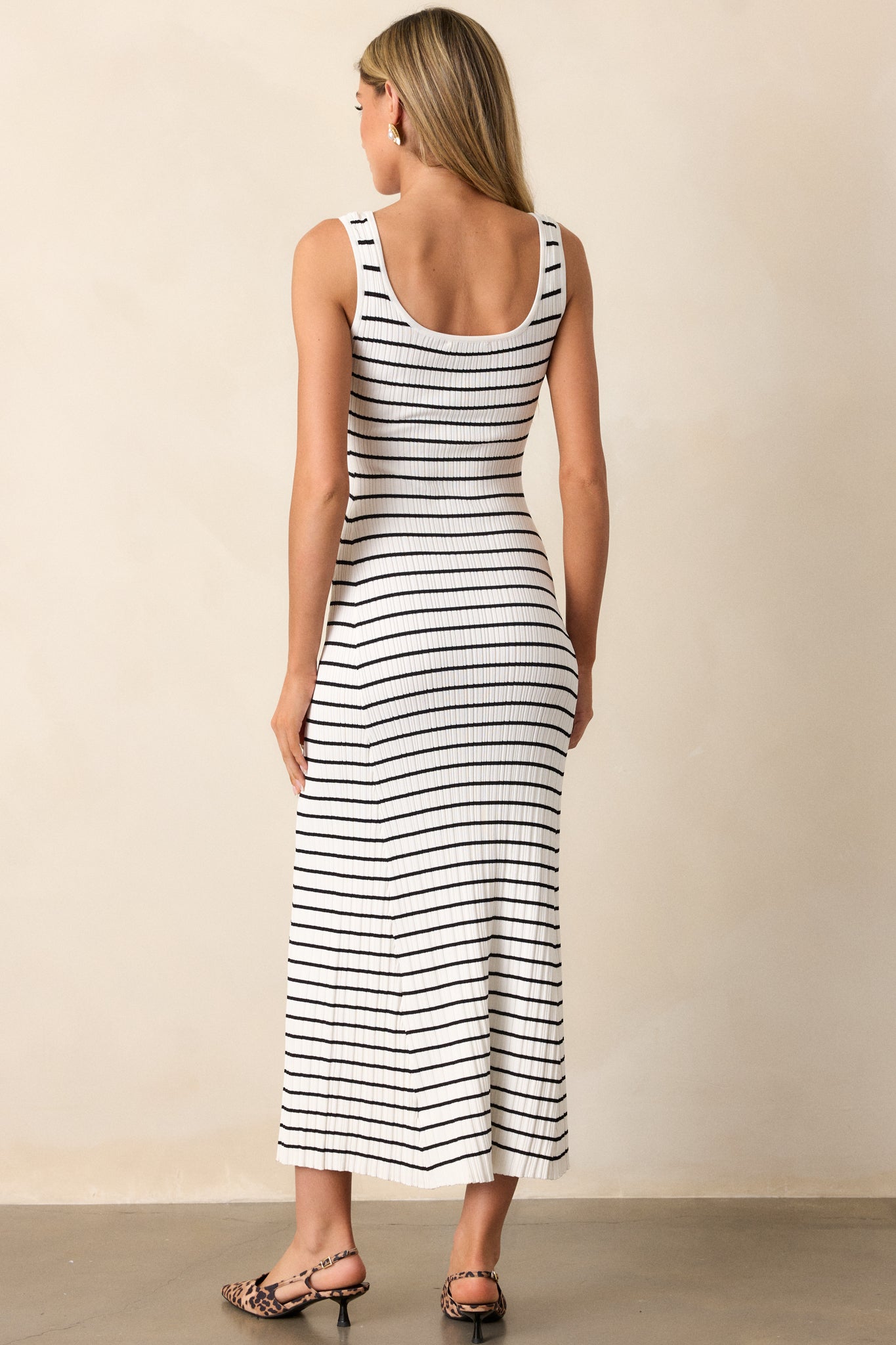 Back view of a black stripe dress highlighting the overall fit, soft ribbed texture, and classic stripe design.