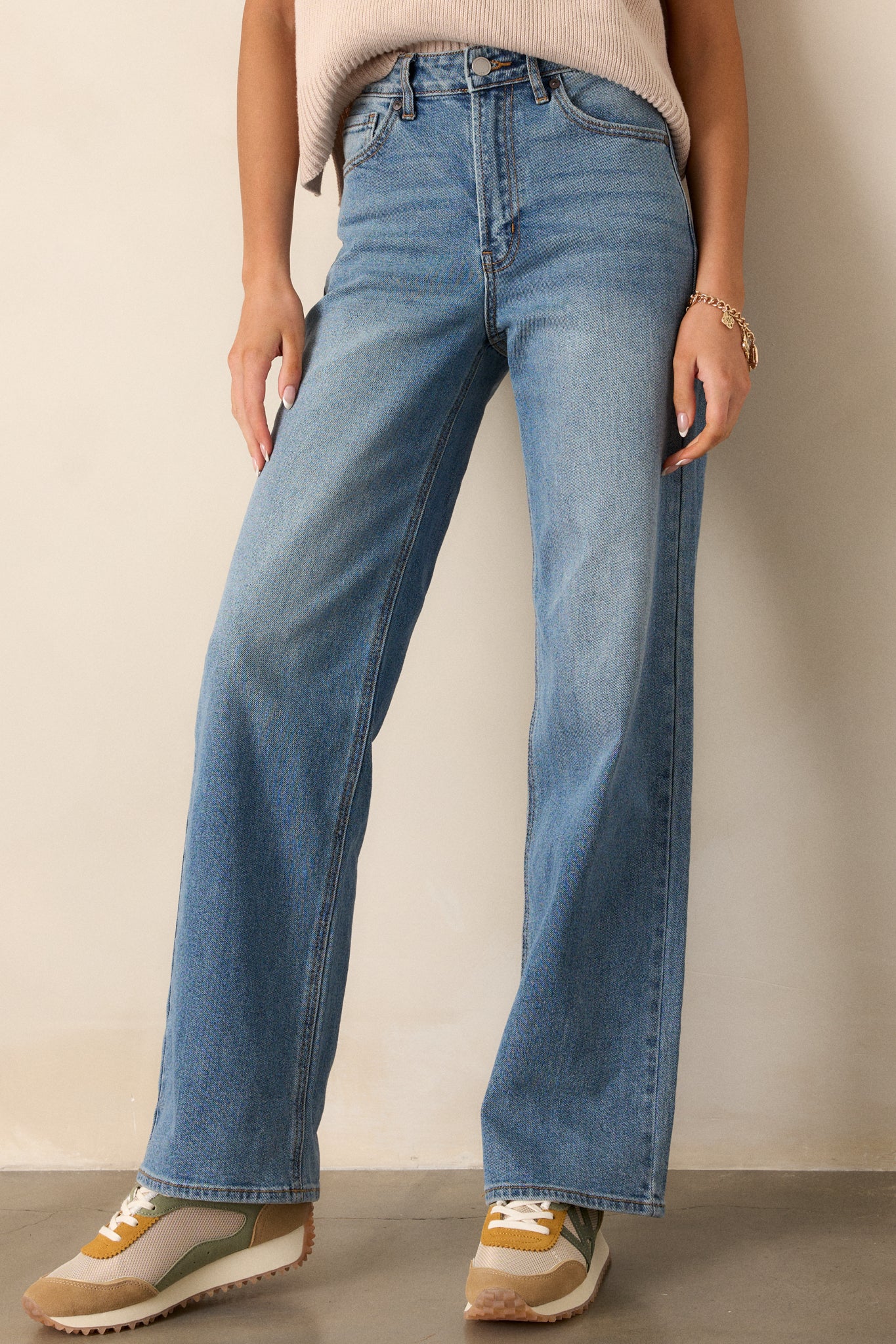 Front view of the jeans featuring functional belt loops, a button zipper closure, functional front pockets, and a wide leg design.