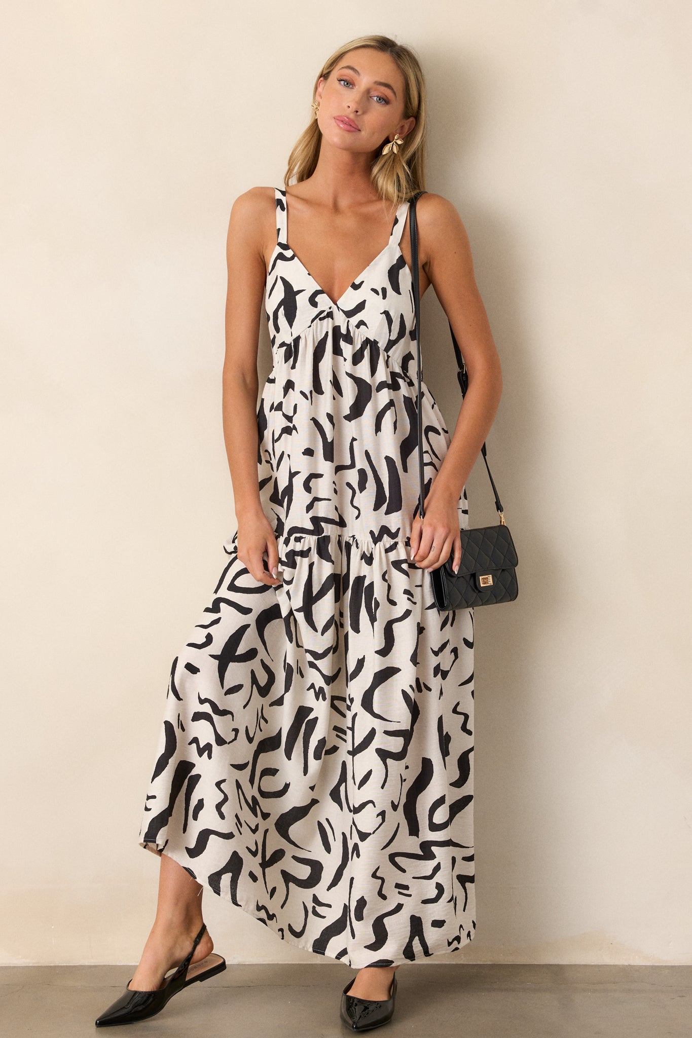 Straight-on view of the dress, emphasizing the v-neckline and contrasting black abstract pattern on the white fabric.