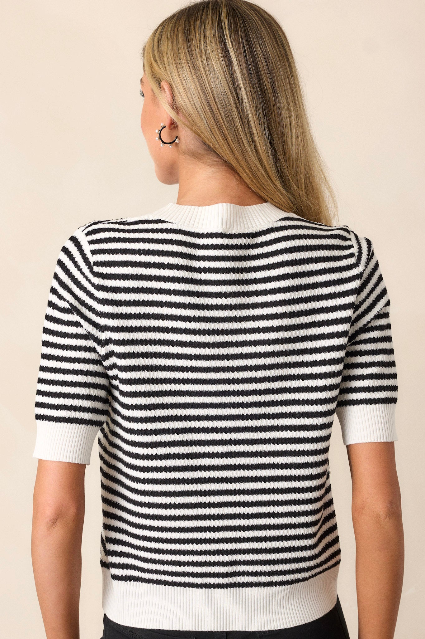 A back view of the top, highlighting the clean lines and the continuation of the stripe pattern, showcasing the overall construction and style of the piece.