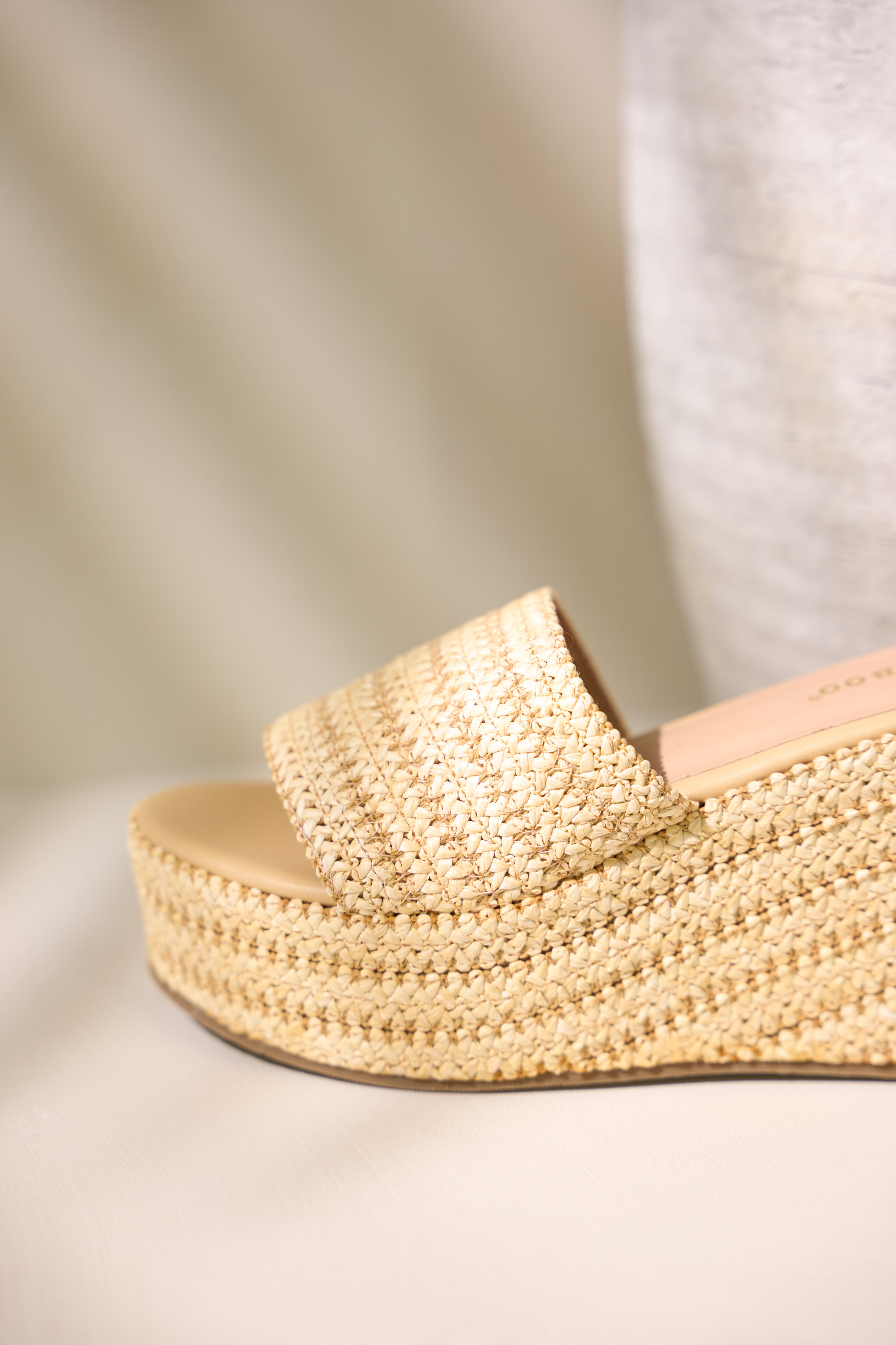 Close-up view of the rounded toe of this natural sandal showcasing the slide on style.