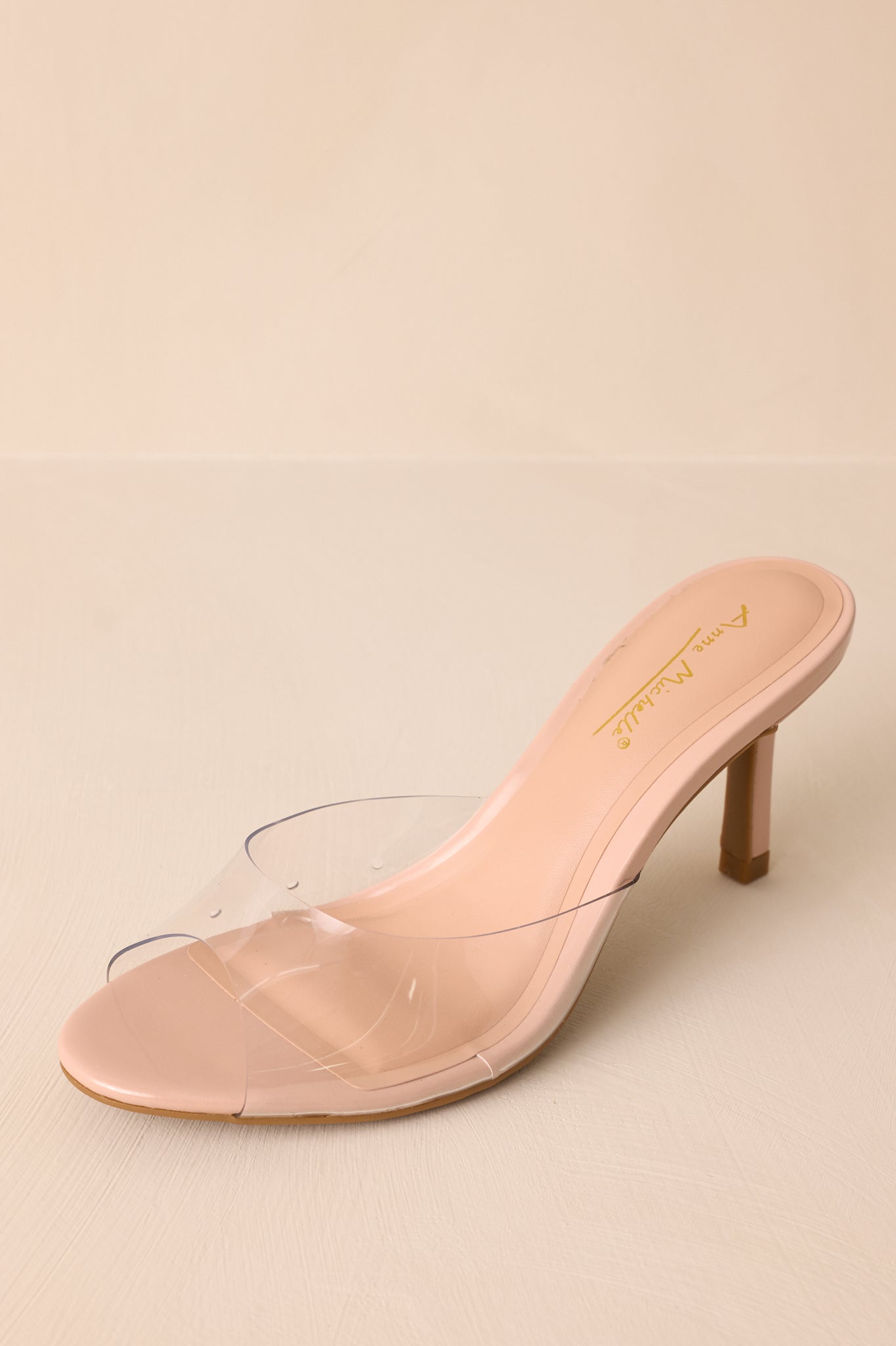 Overhead view of these nude heels that feature a rounded toe, a clear thick toe strap and extra heel cushioning.