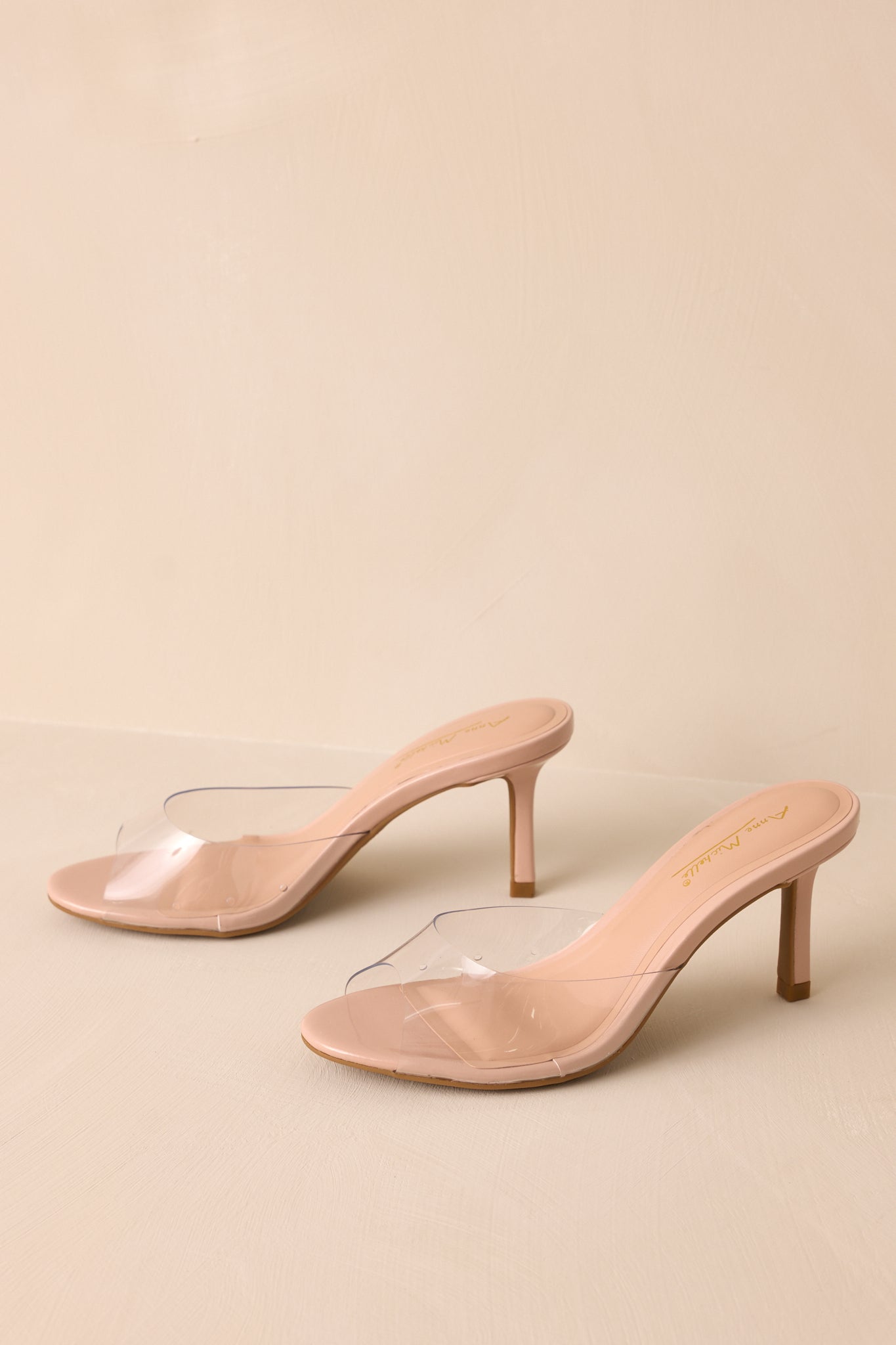 Side overhead view of these nude heels that feature a rounded toe, a clear thick toe strap and extra heel cushioning.