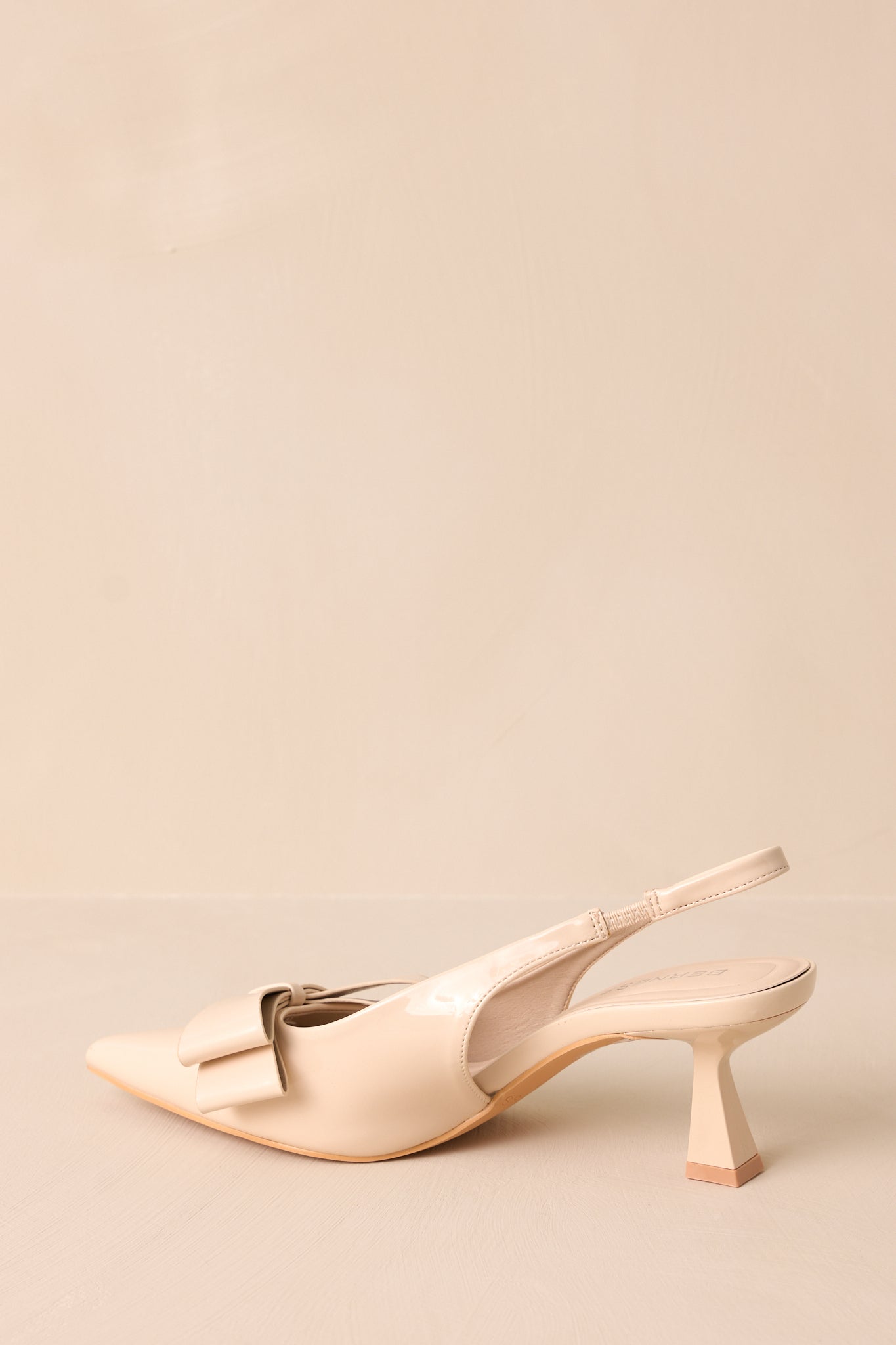 The back view of the ivory heels, highlighting the slingback strap and the short kitten heel, demonstrating the combination of comfort and style.