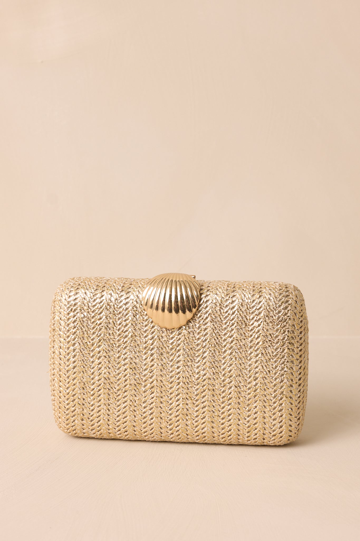 A close-up of the gold woven pattern, showcasing the intricate design and texture of the clutch's surface.