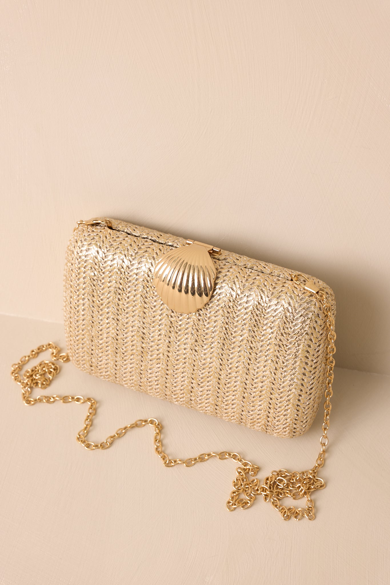 A view of the clutch with the crossbody chain attached, showing the bag resting comfortably against the surface.