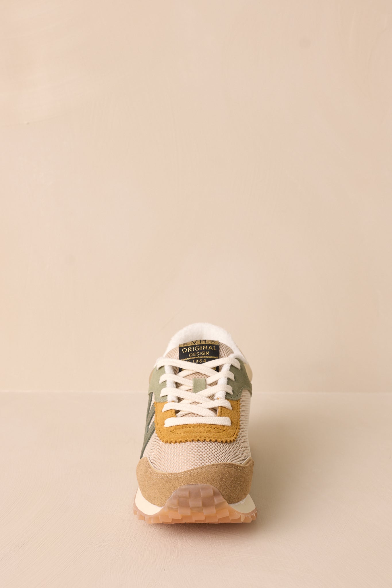 Front view of these camel sneakers that feature a spikey sole detail, white laces and Camel wrap around detailing.