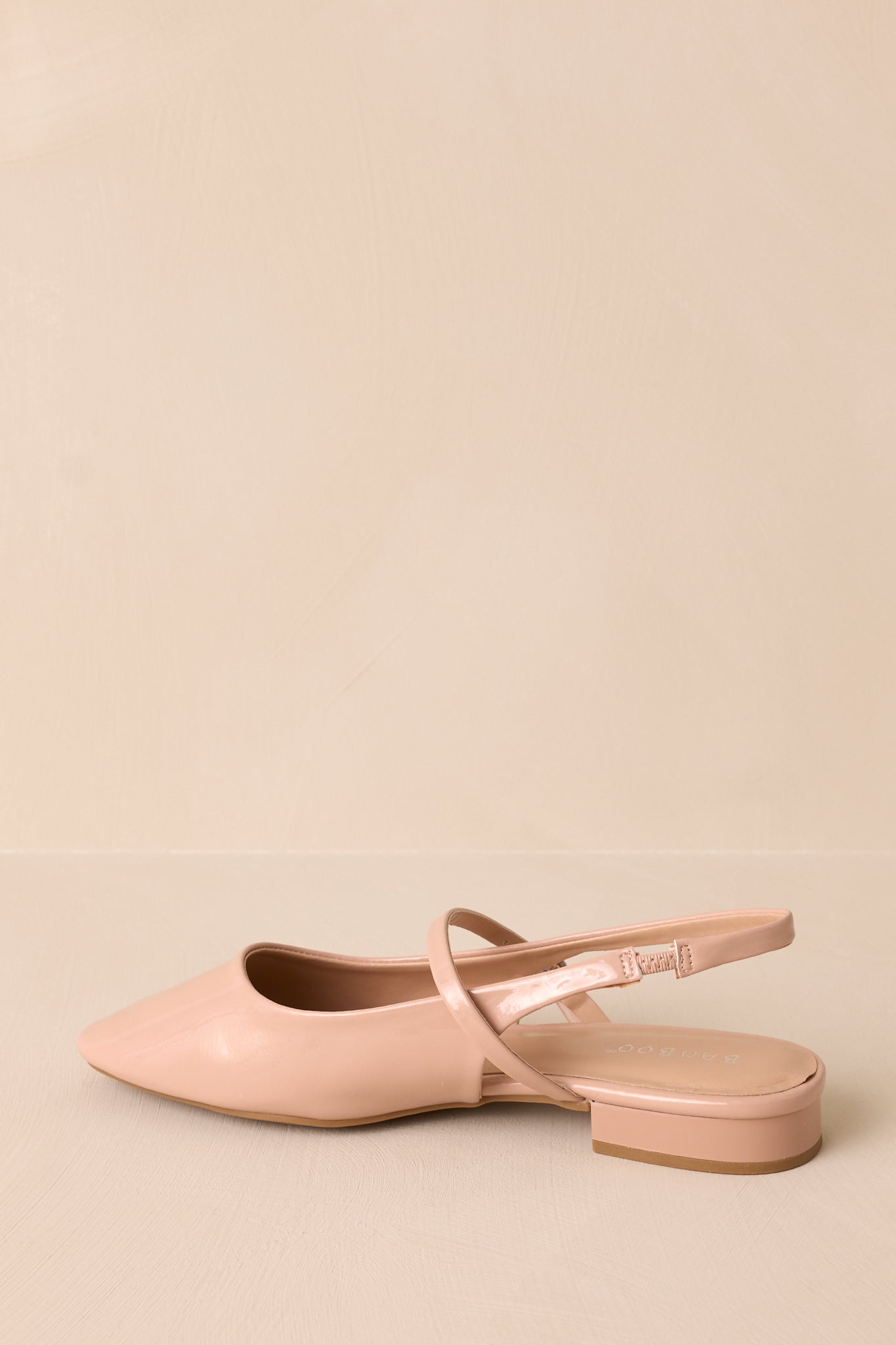 Side view of the beige flat, showcasing the slightly squared toe and slingback strap against a neutral background.