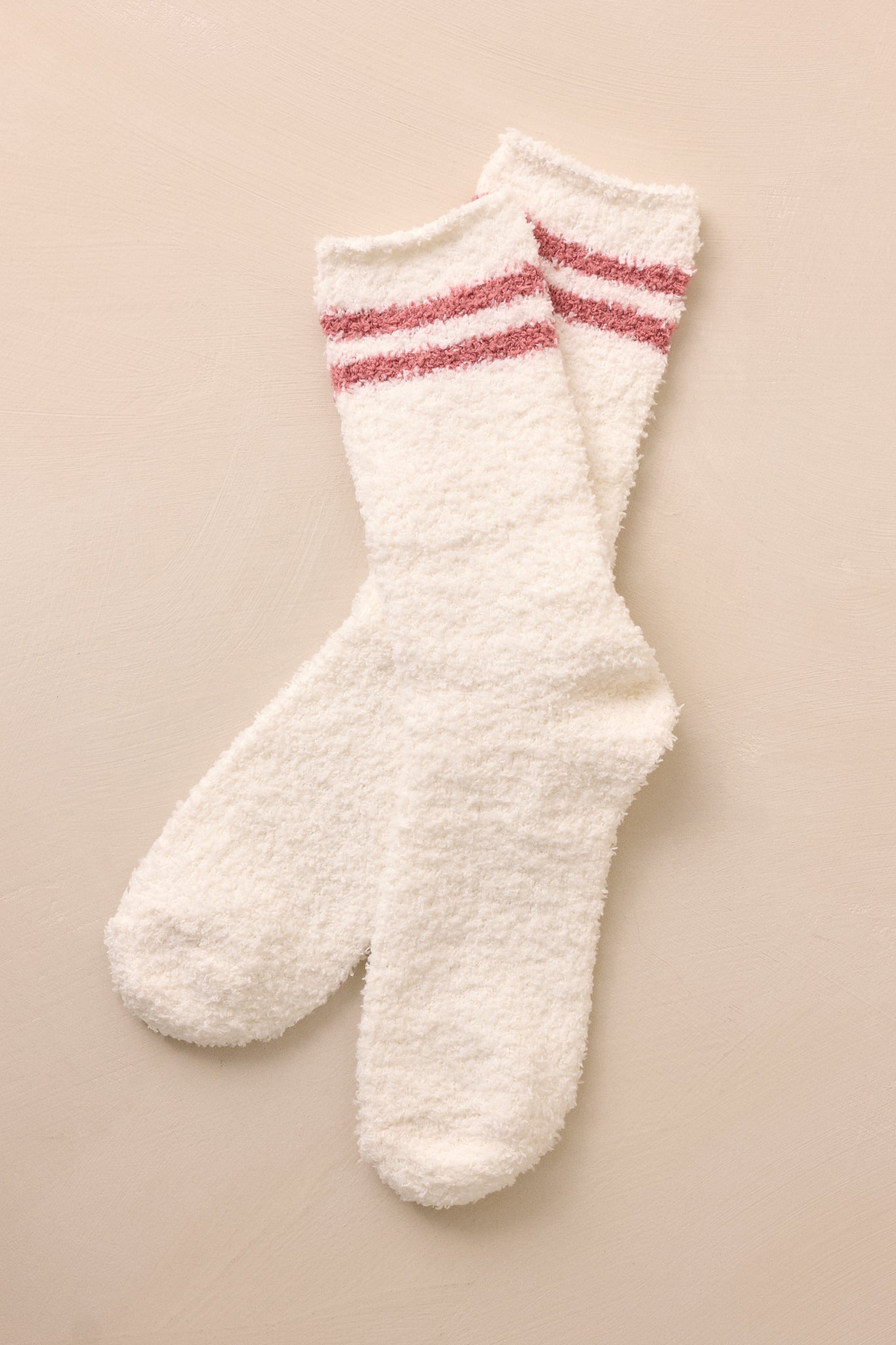 These white socks feature a fuzzy material, hit around the lower calf, and two red stripes decorated on the top of the sock.