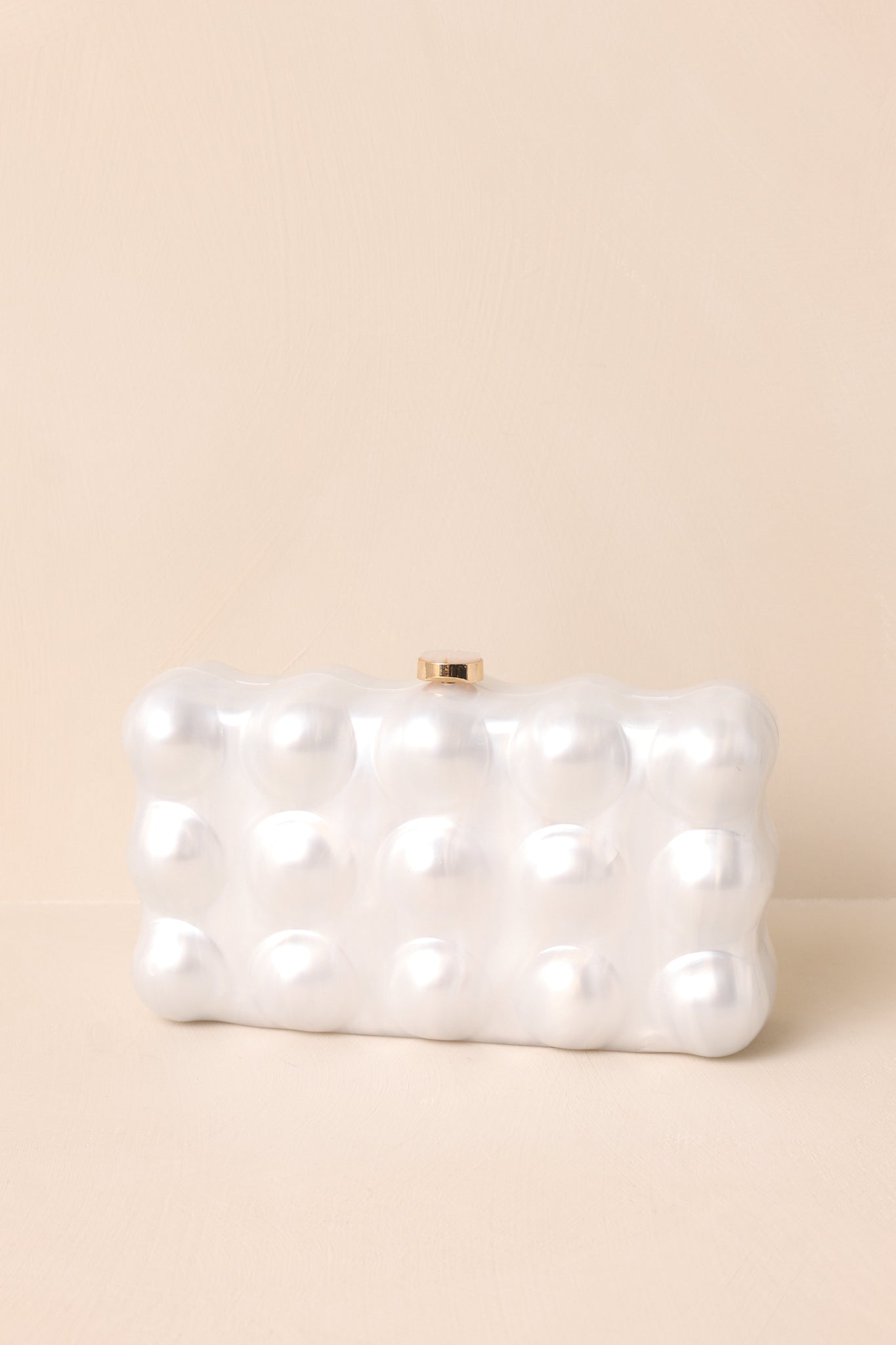 A minimalistic rectangular clutch with a smooth pearlized bubble texture, highlighted by a gold-tone clasp, displayed upright without the chain.