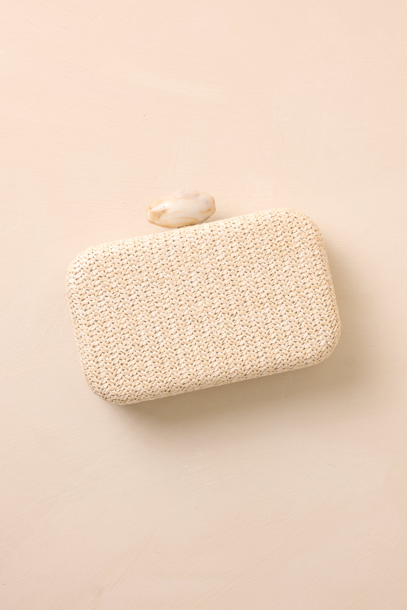 Top-down view of the clutch on a beige surface, showcasing its sleek design and compact size, perfect for a night out.