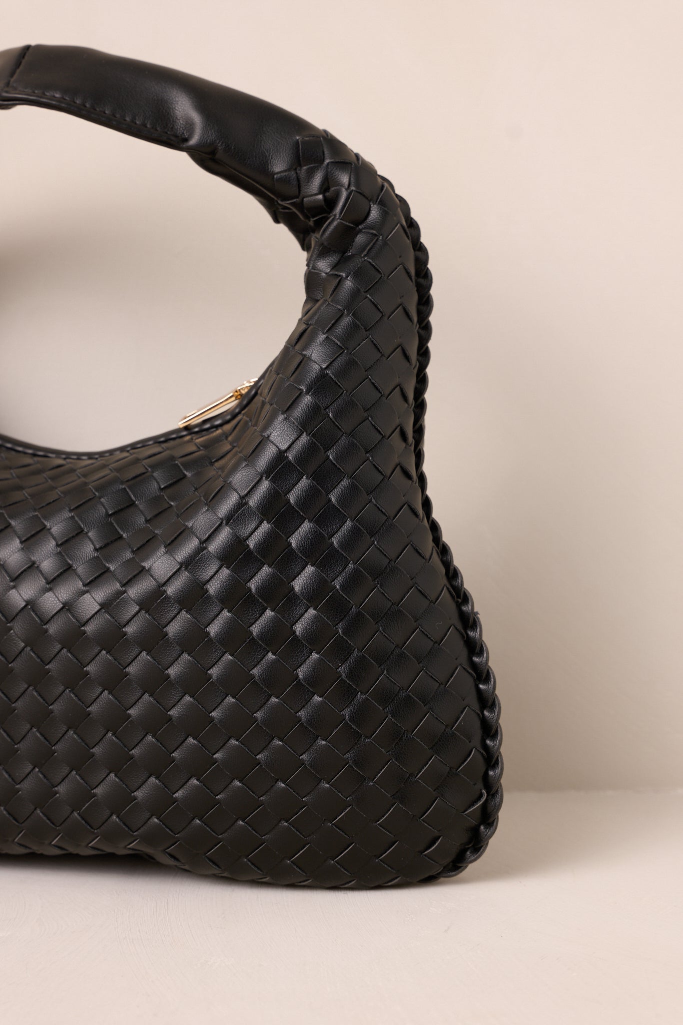 Focused shot of the woven material and gold zipper closure, highlighting the handbag's stylish texture and secure fastening.